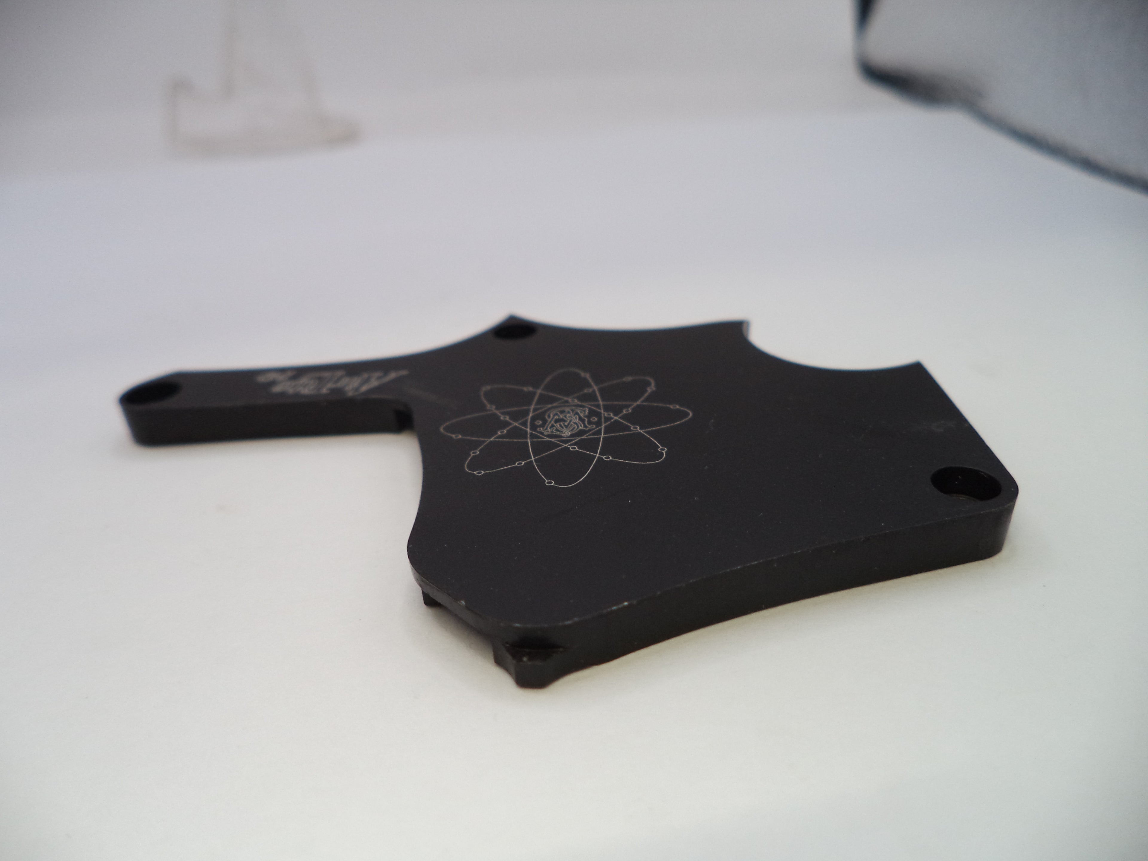 Black metal object with a symbol on a white background