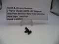 Three black screws on a white surface with a label describing them.