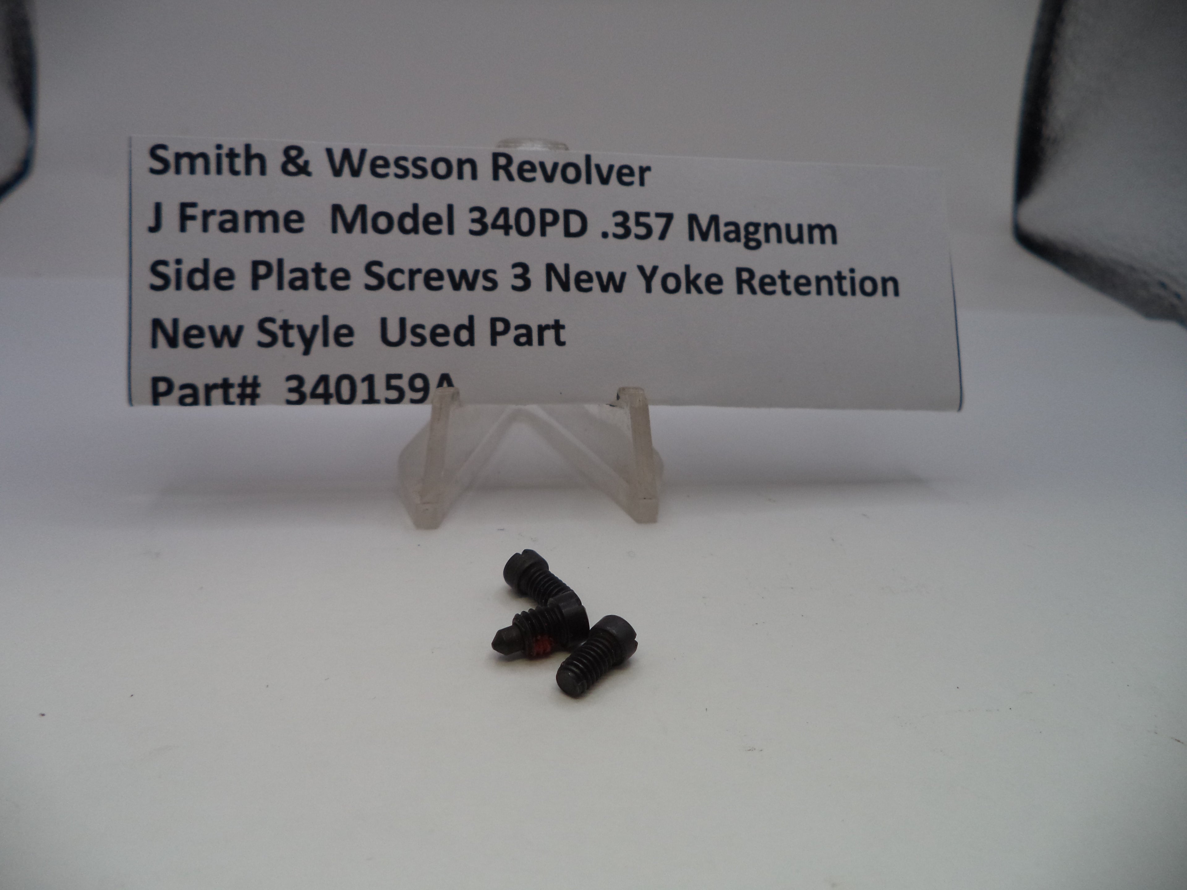 Three black screws on a white surface with a label describing them.