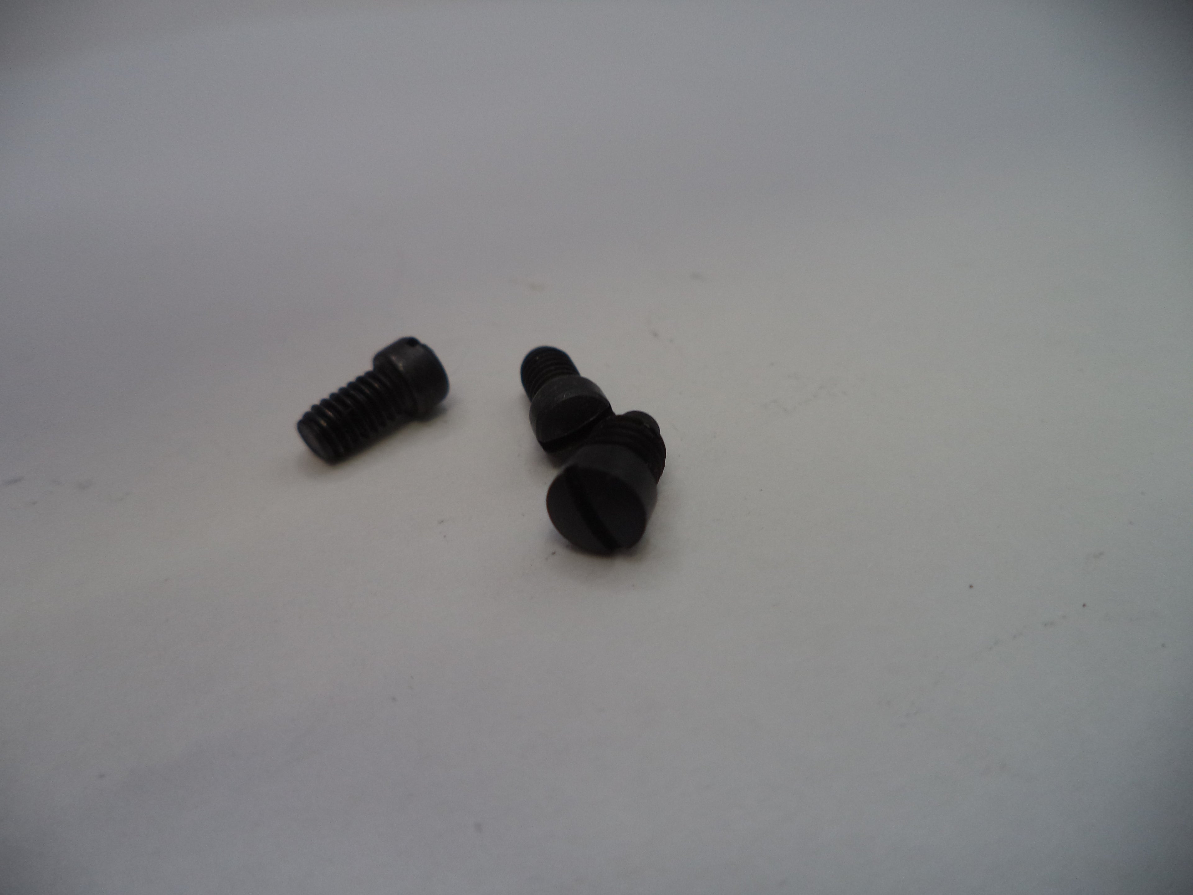 Two black screws on a white surface