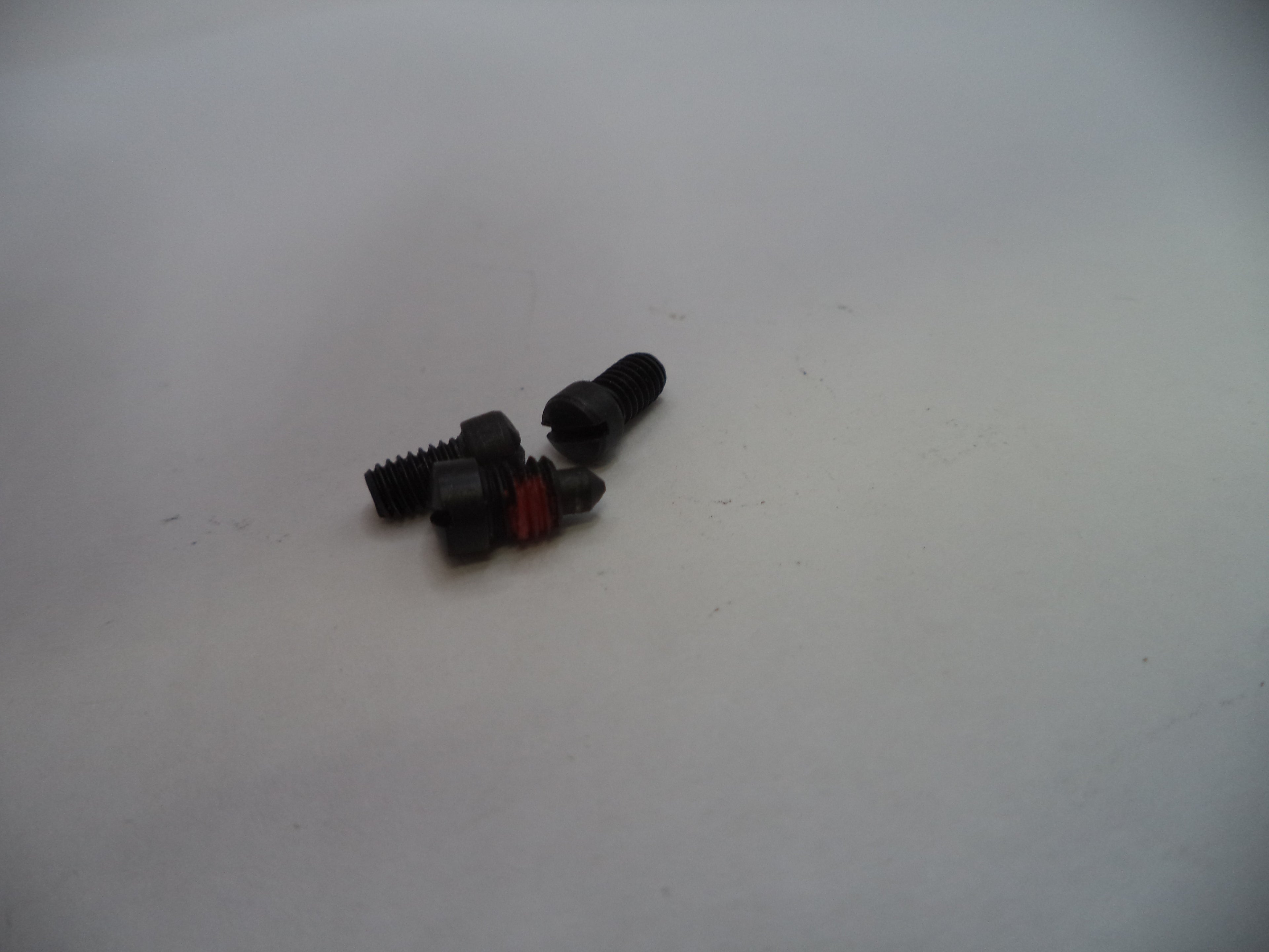 Three small black screws on a white surface