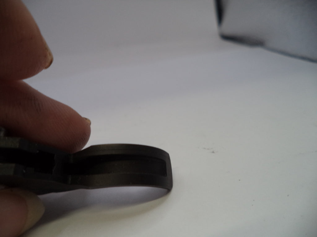 Person holding a black rubber band on a white surface
