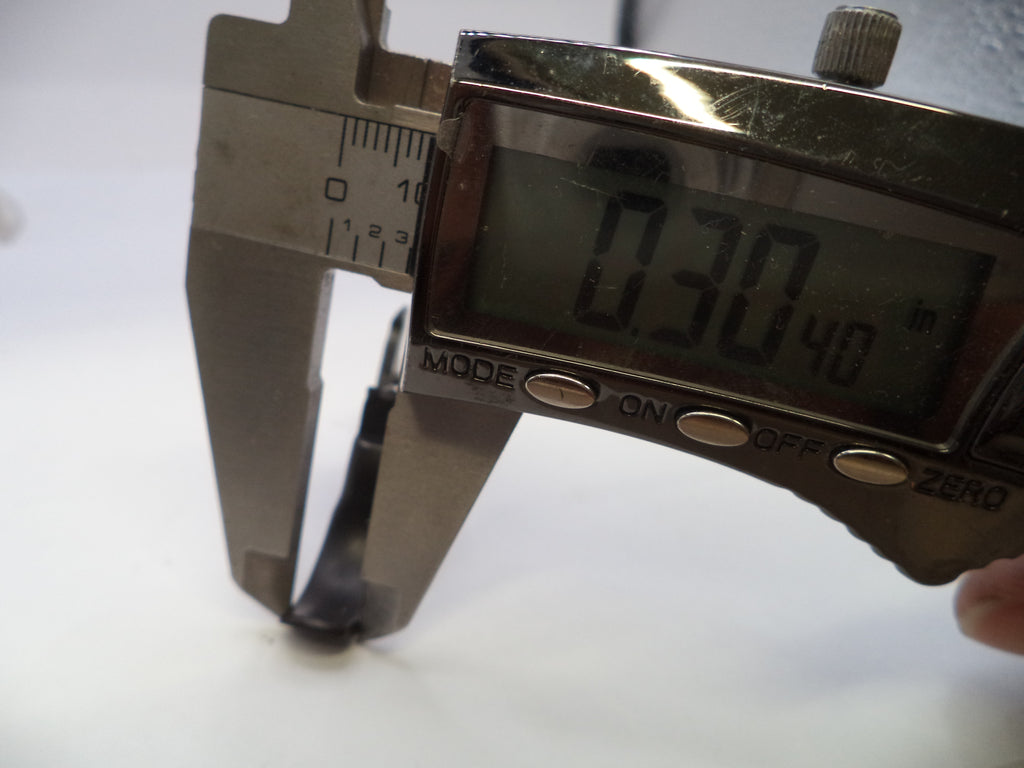Digital caliper measuring a small object with a white background