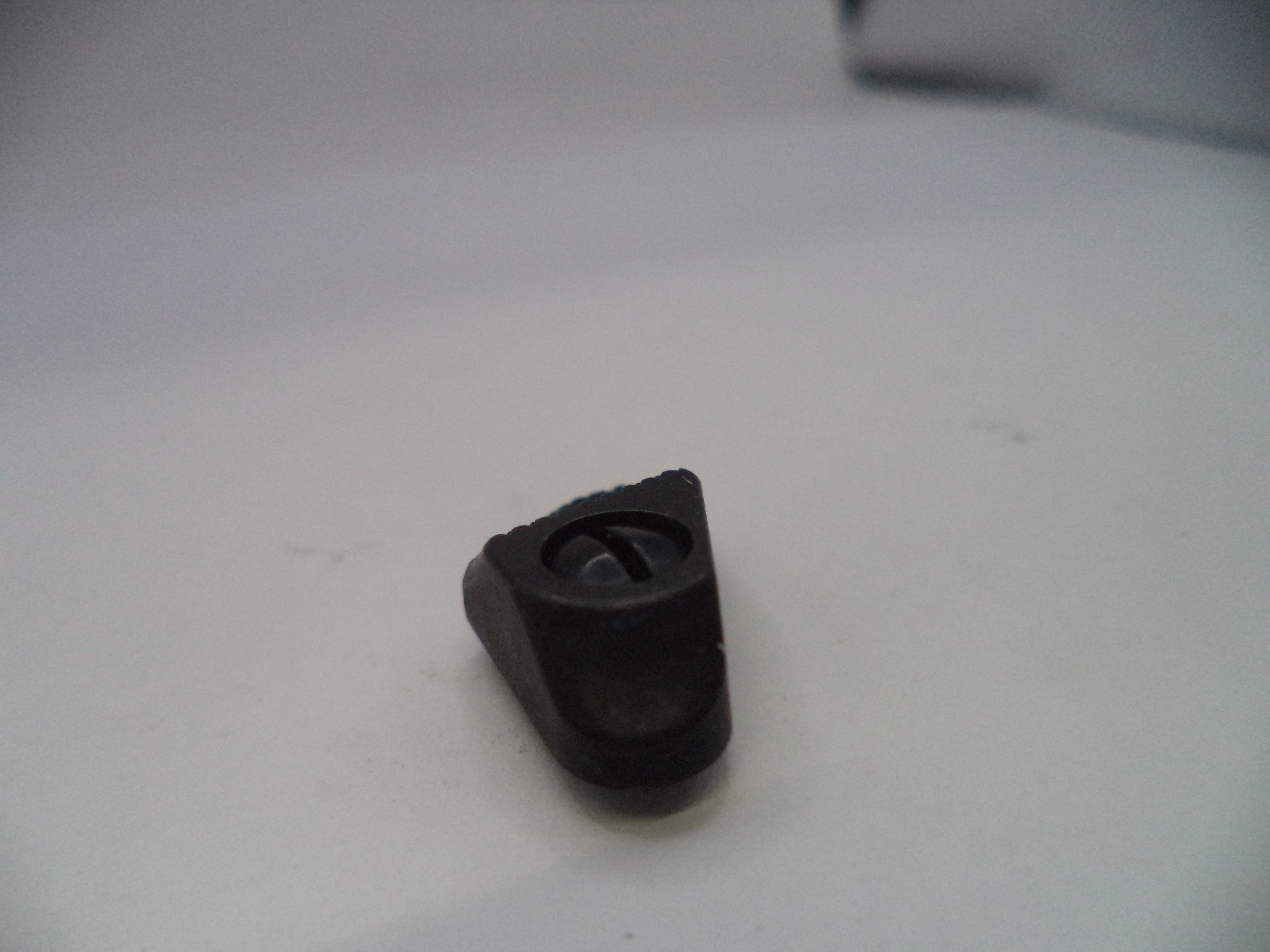 Black plastic component on a white surface