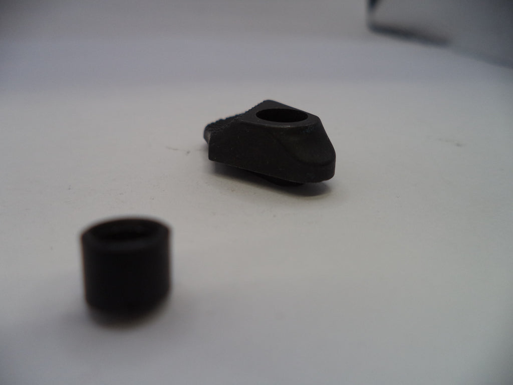 Two black rubber grommets on a white surface
