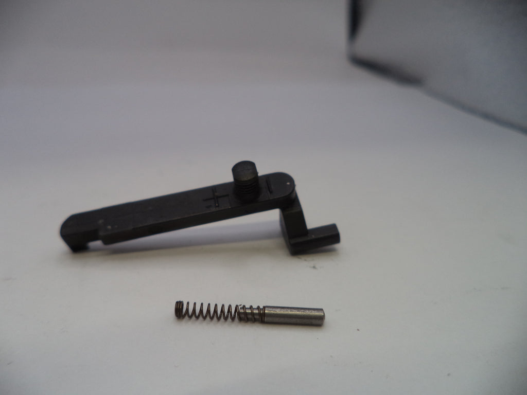 Black metal tool and spring on a white surface