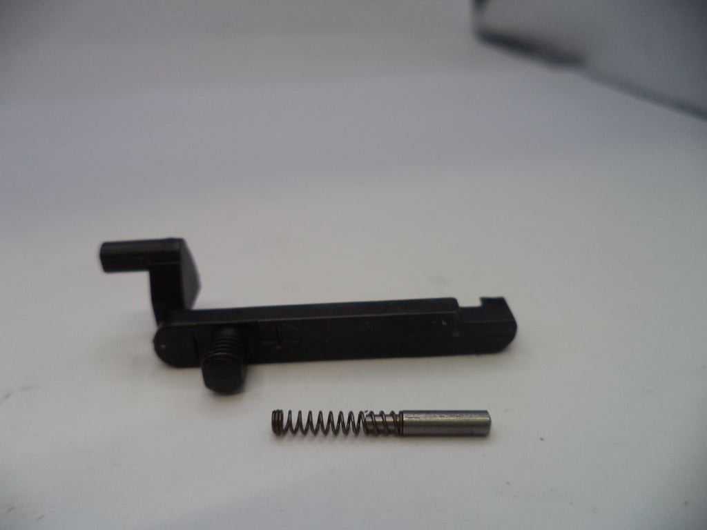 Black metal component with a spring on a white surface