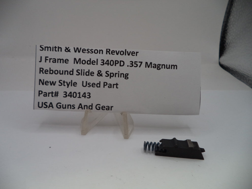 Smith & Wesson revolver slide and spring with a label on a white background