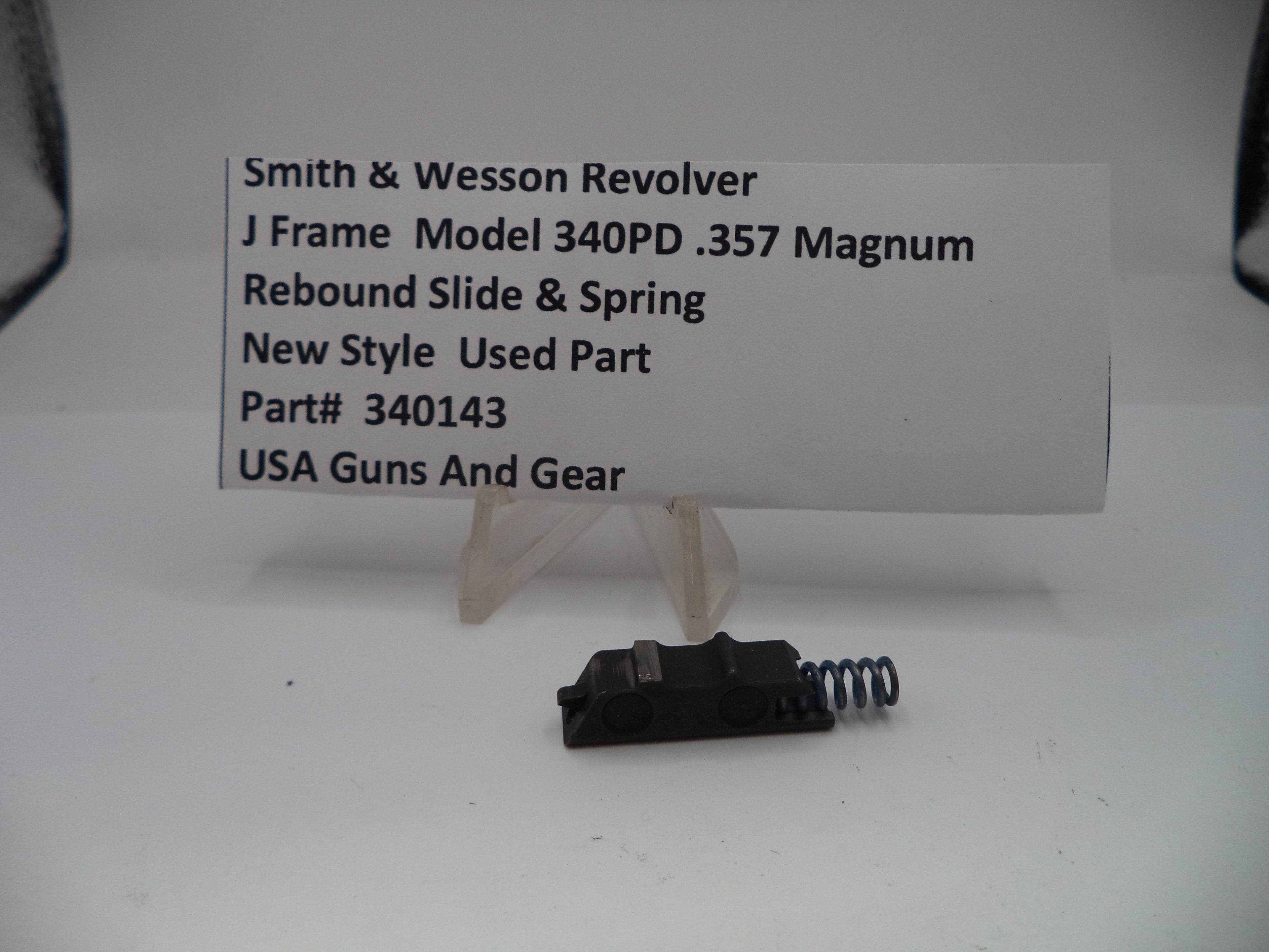 Smith & Wesson revolver rebound slide and spring with a descriptive card on a white background