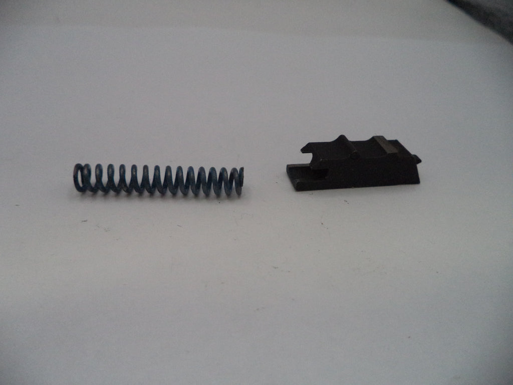 Black spring and black metal bracket on a white surface