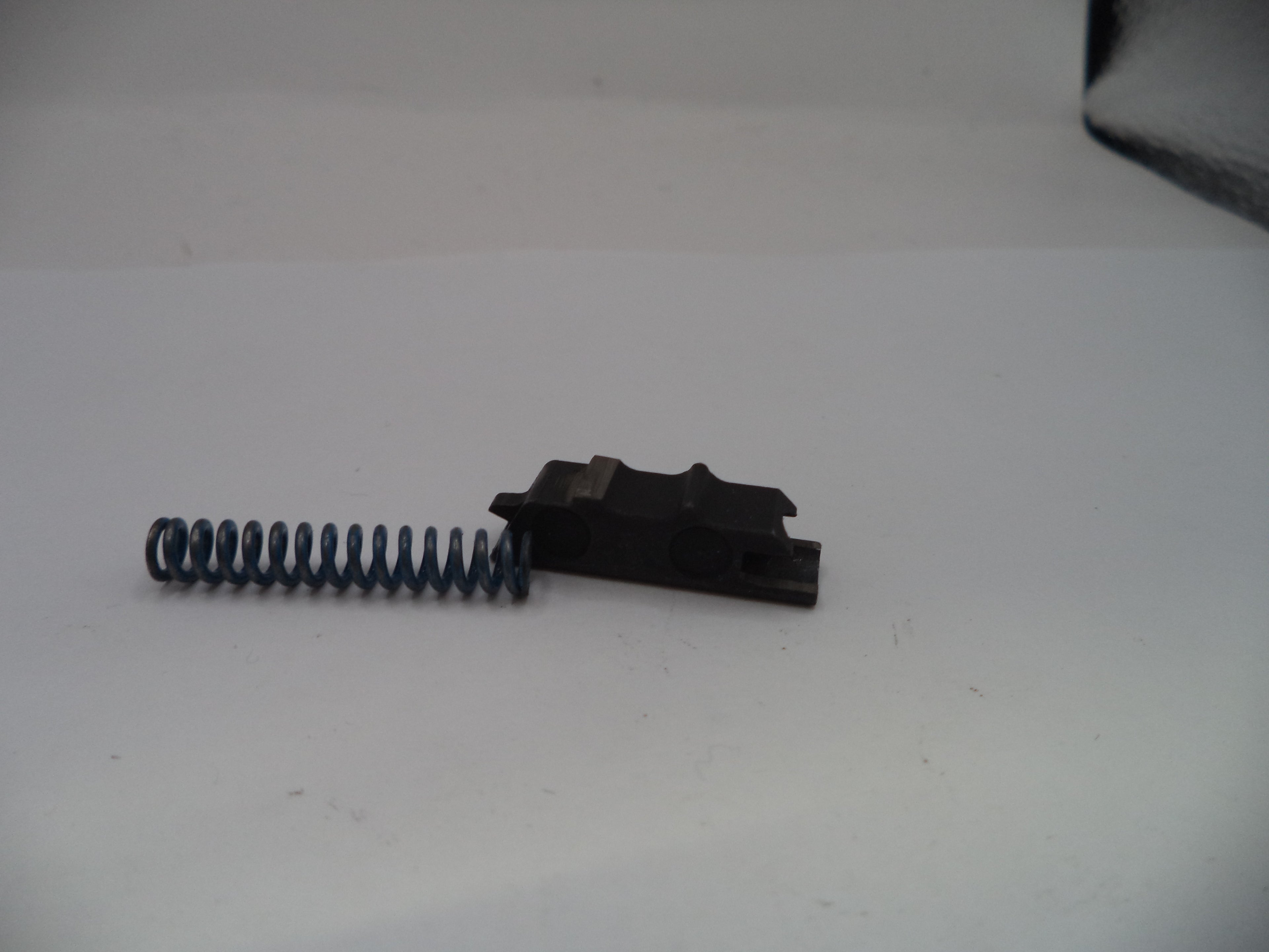 Black metal component with a spring on a white background