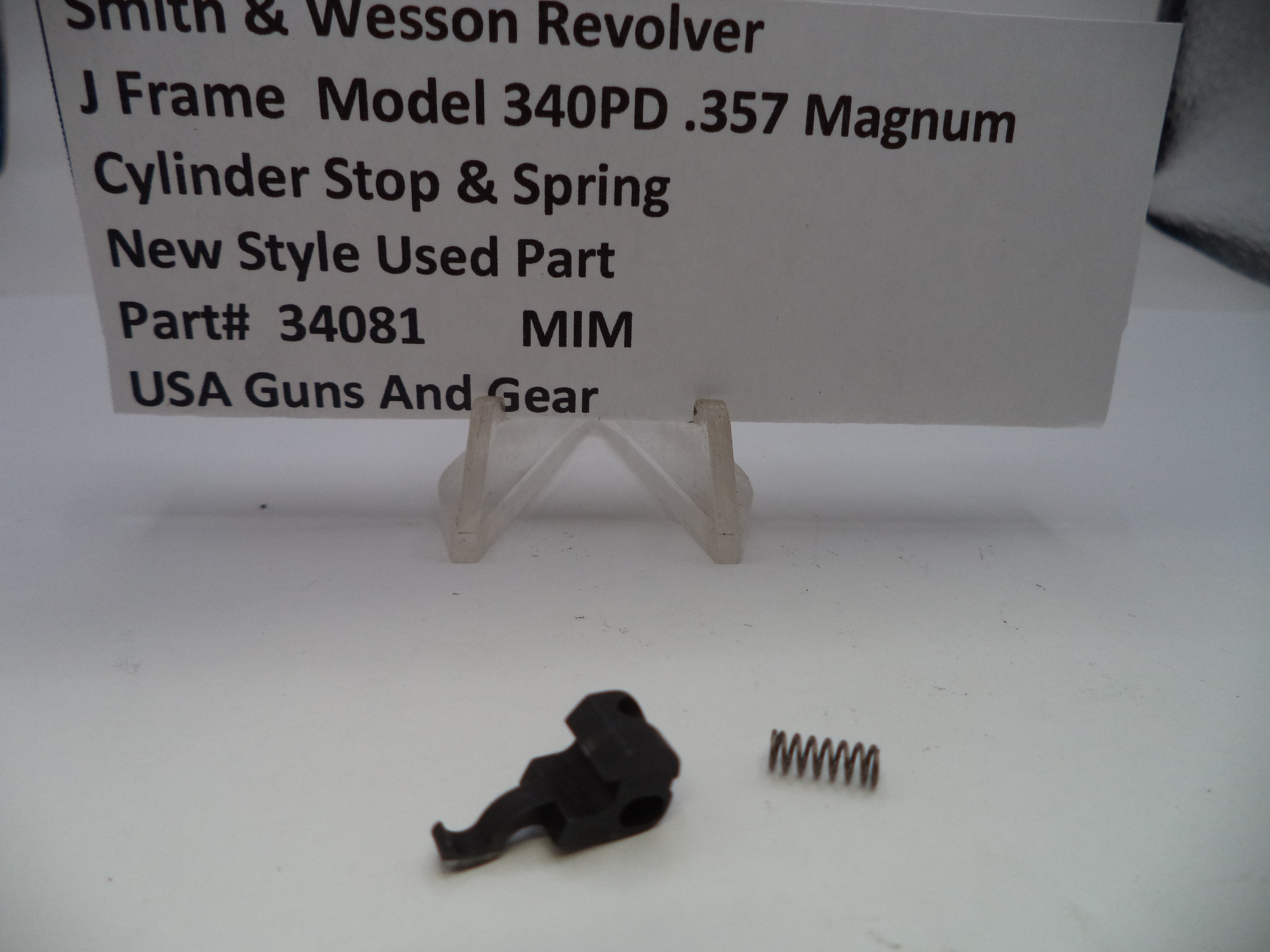 Smith & Wesson revolver cylinder stop and spring with a label on a white background