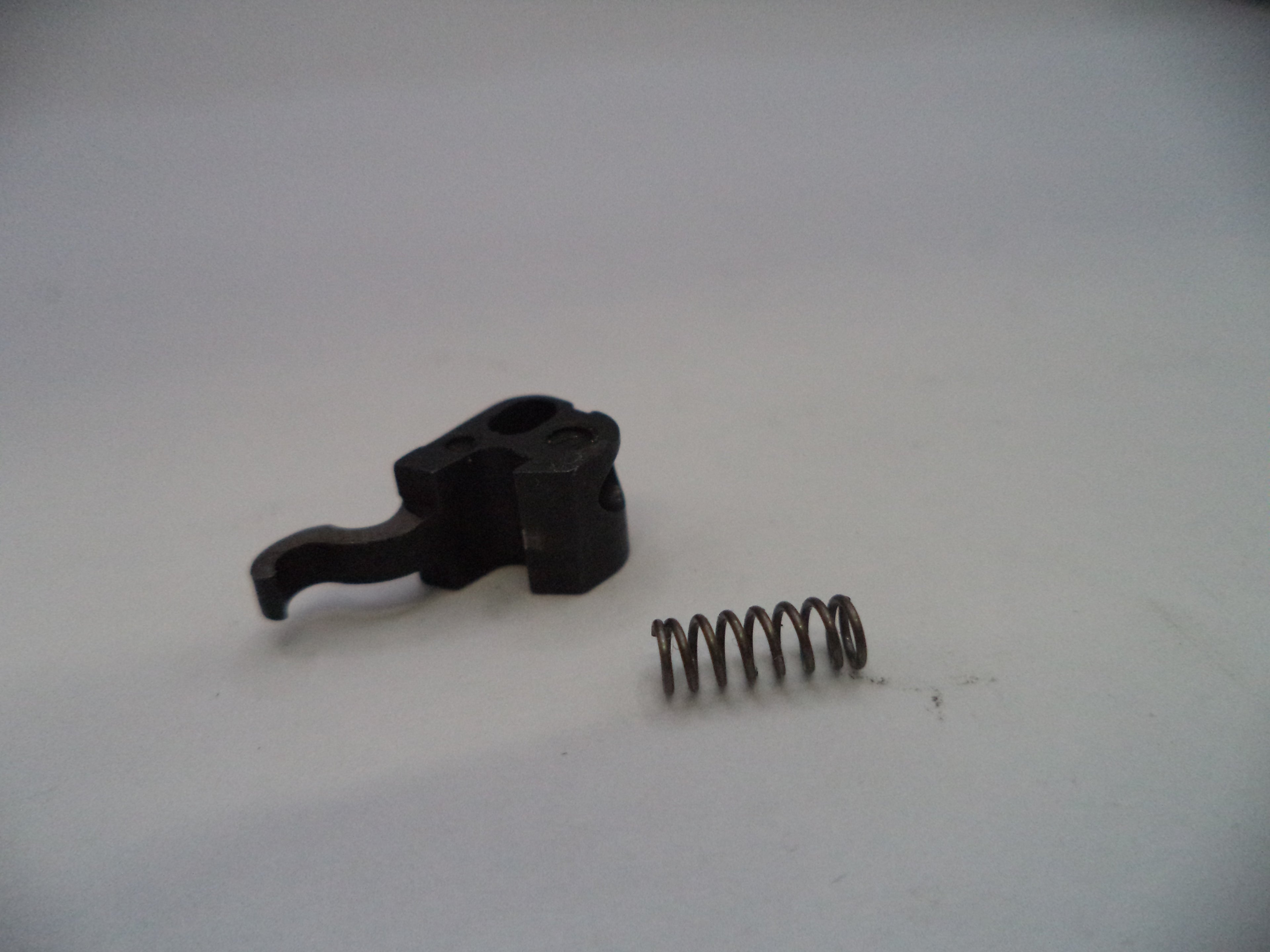 Black mechanical component and spring on a white background