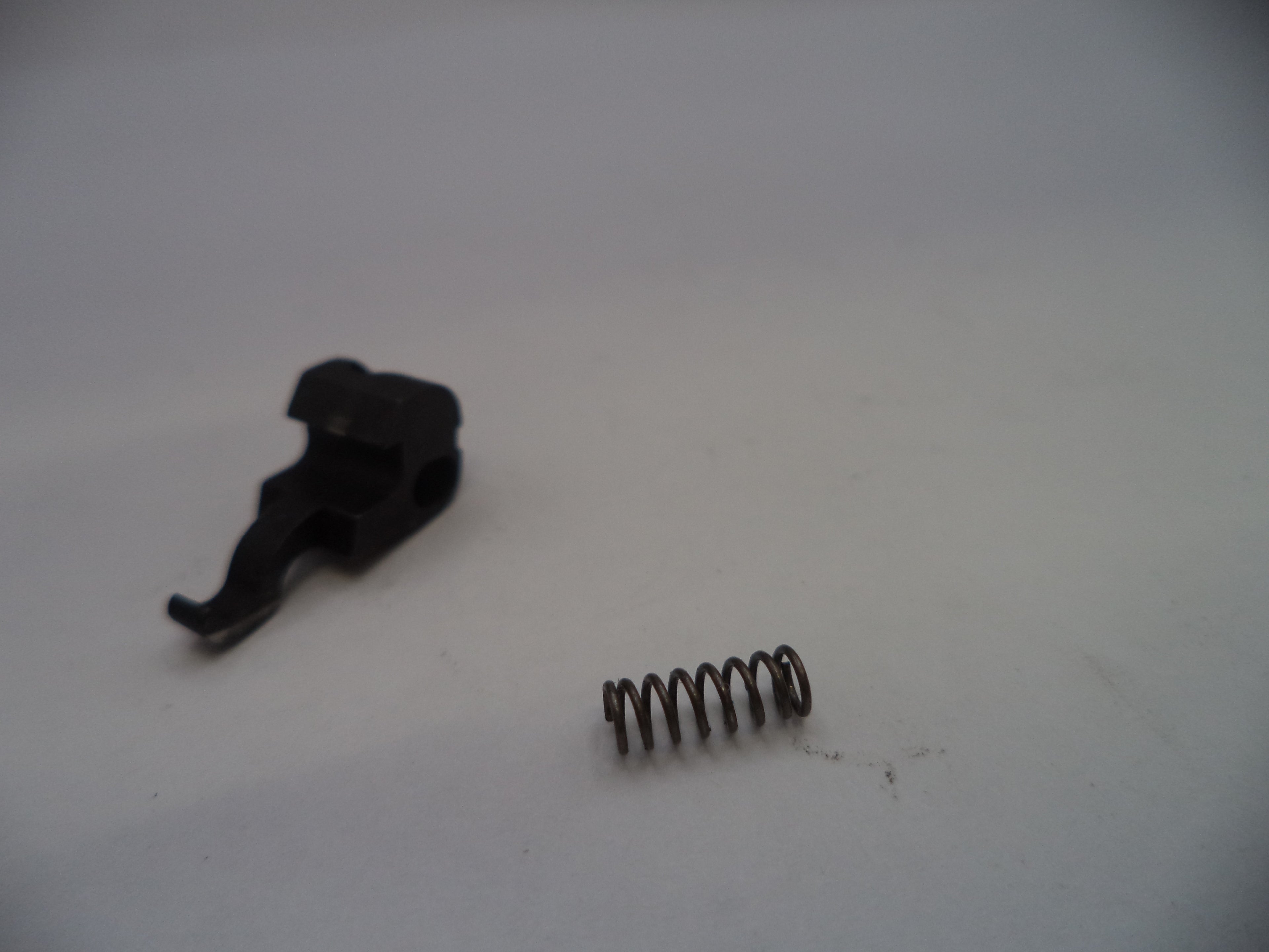Black plastic clip and metal spring on a white background