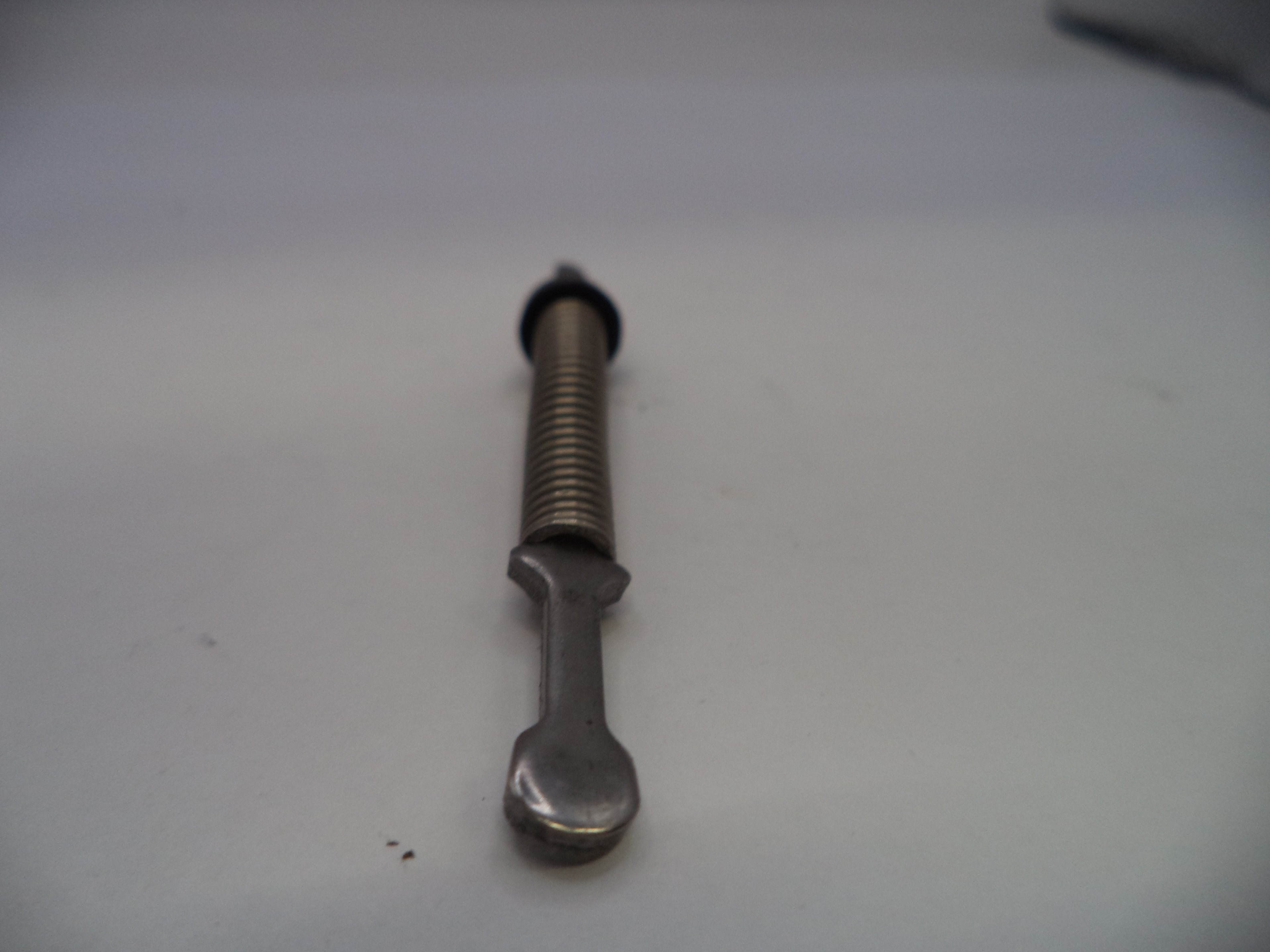 Metal bolt with a spring on a white surface