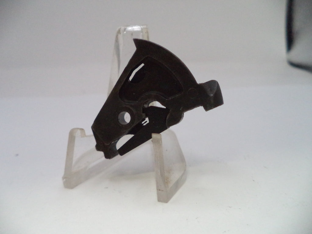Black metal object on a clear stand against a white background
