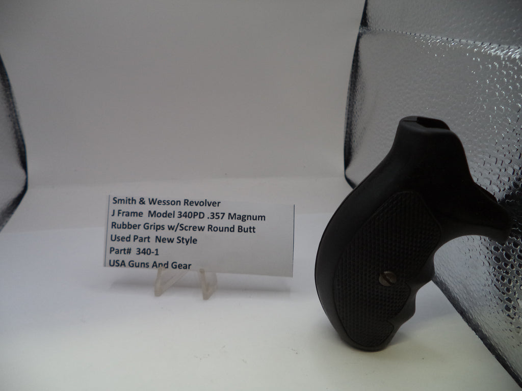 Black gun grip on a white surface with a label in the background