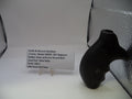 Black gun grip on a white surface with a label in the background