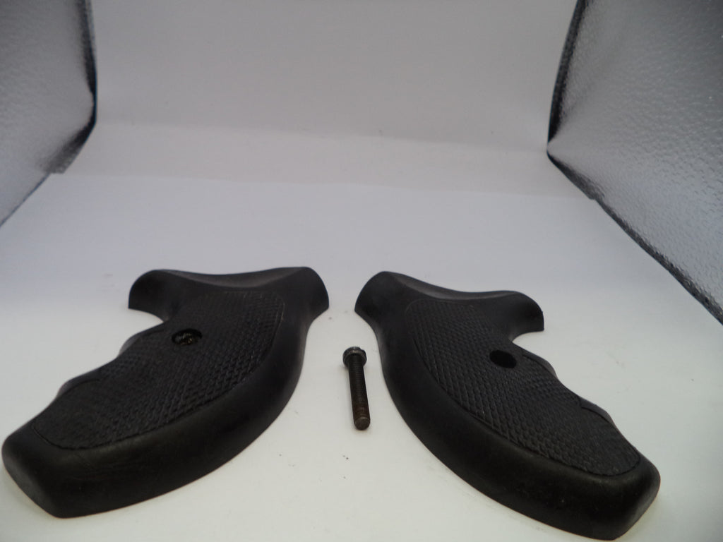 Two black rubber gun grips with a small metal screw on a white surface.