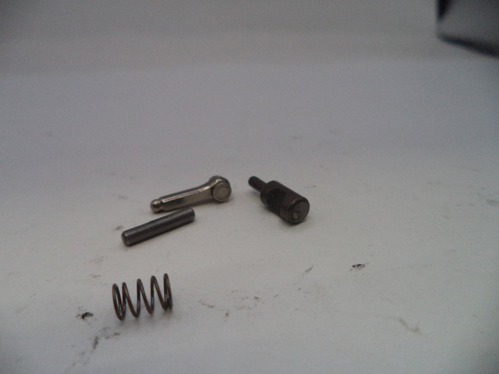 Three metal springs and a bolt on a white surface