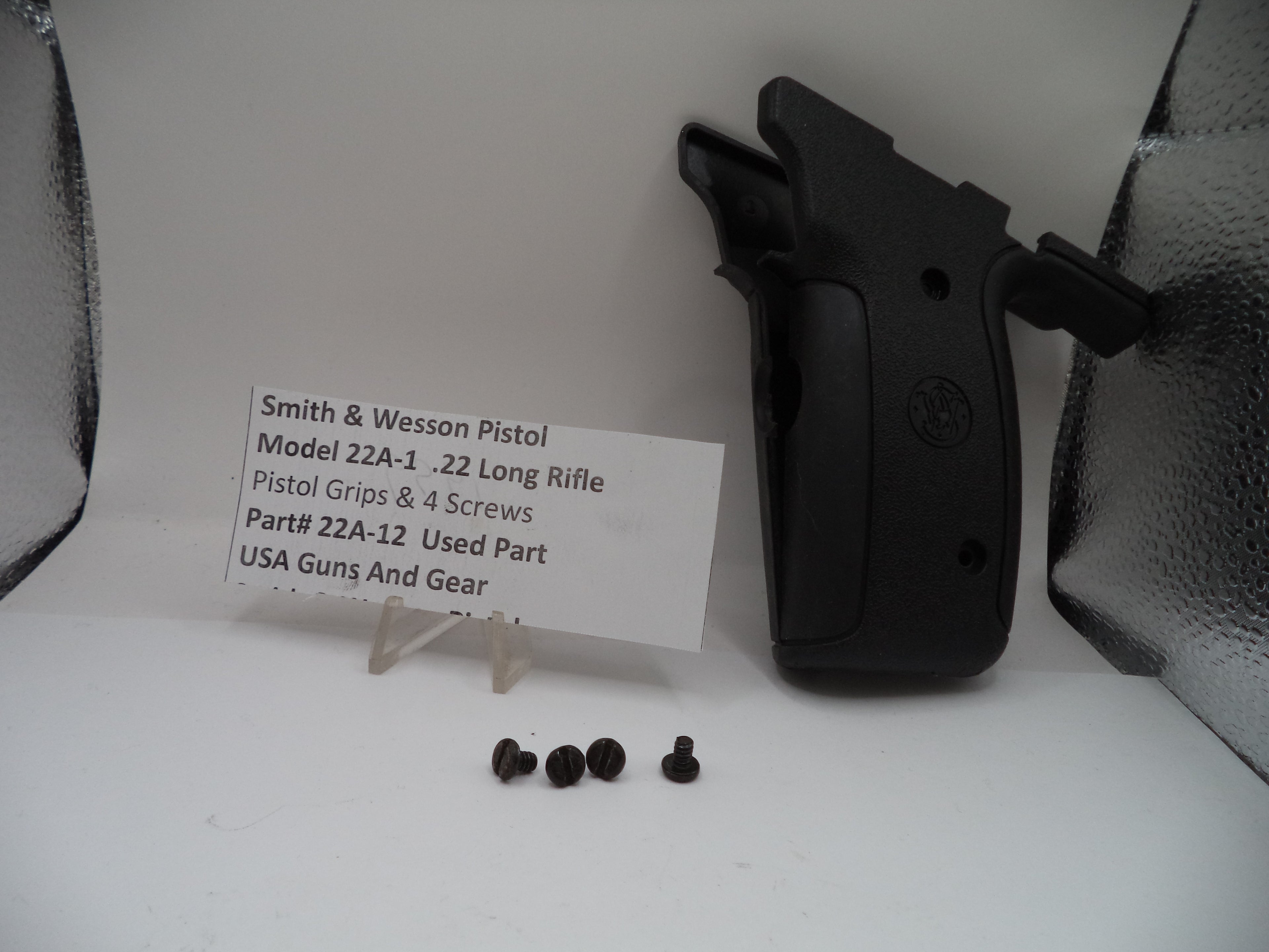 Smith & Wesson pistol grip and screws on a white background with a label.