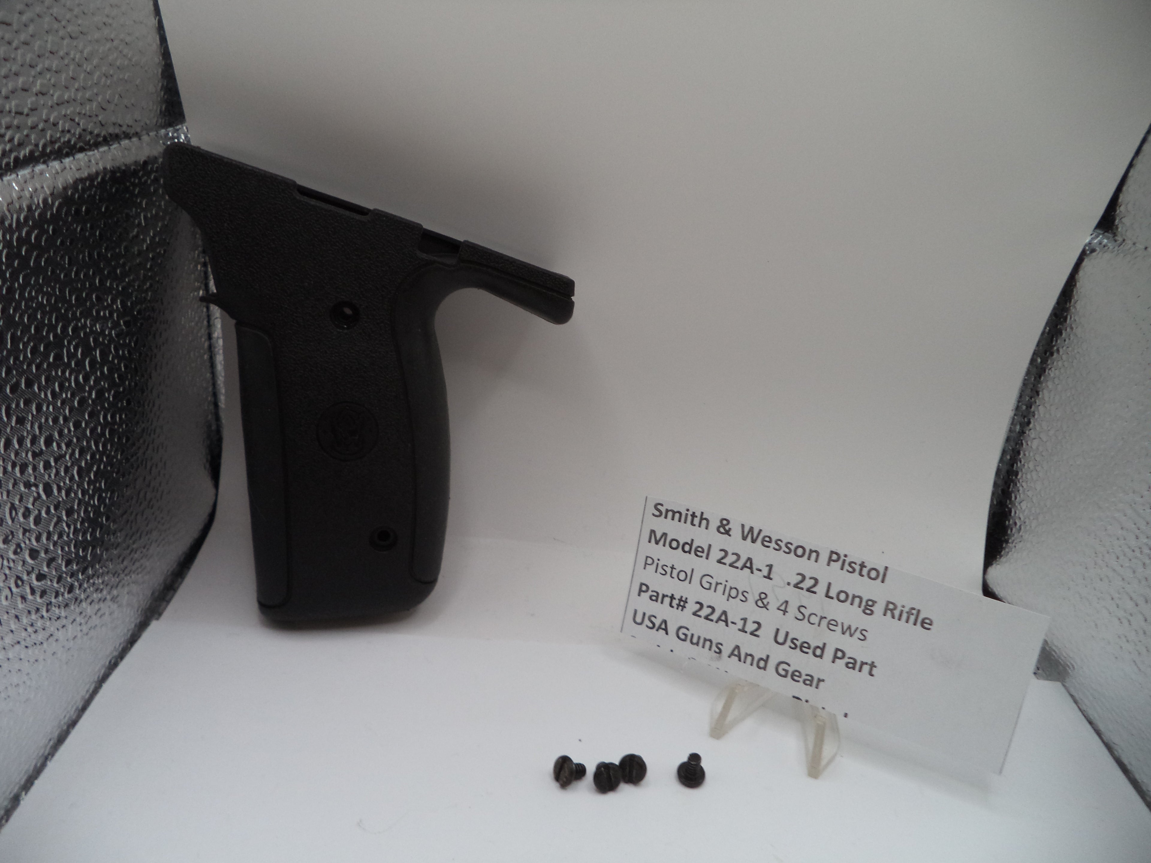 Smith & Wesson pistol with screws on a white background