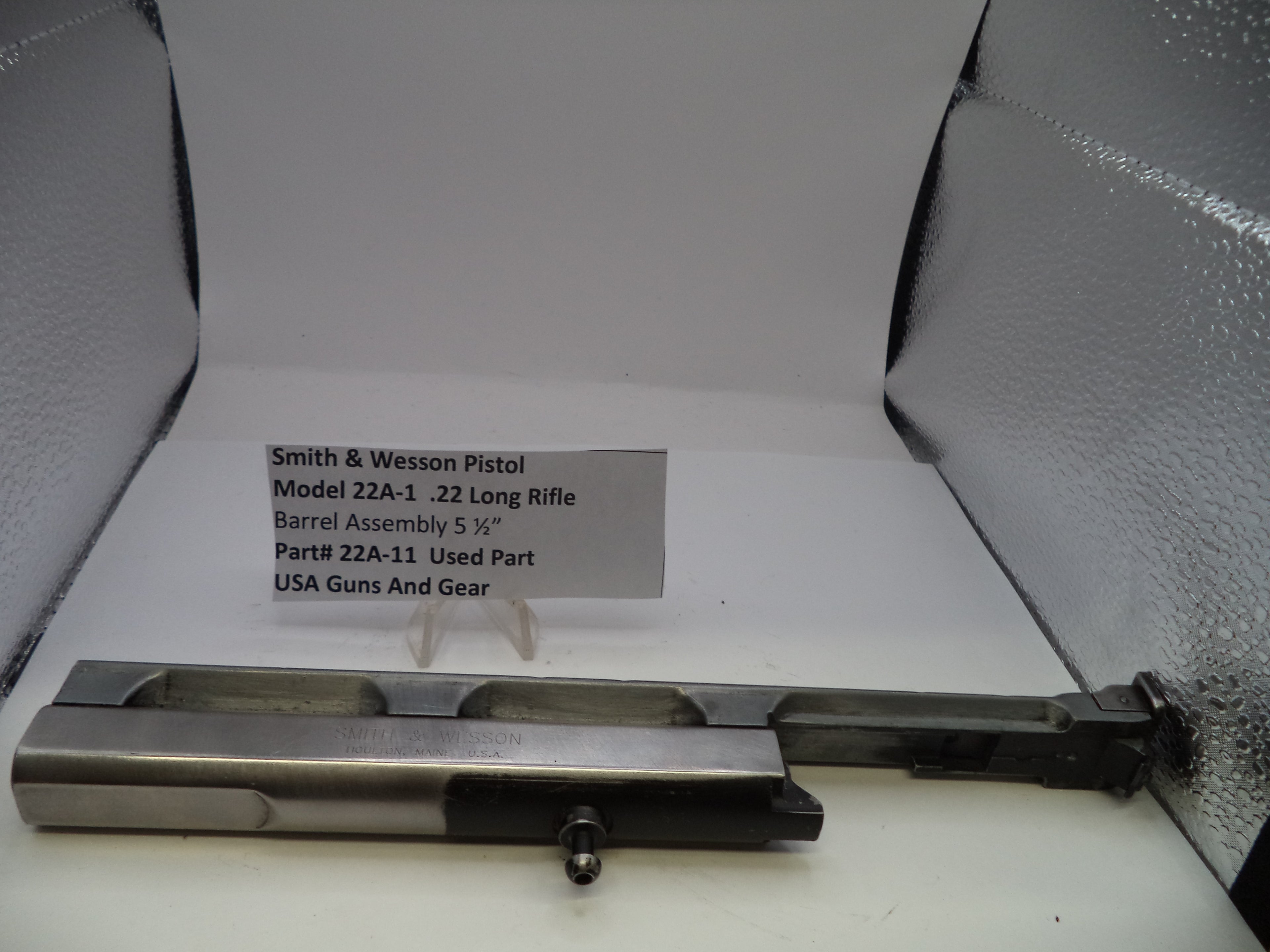 Smith & Wesson pistol barrel assembly on a white background with a label.