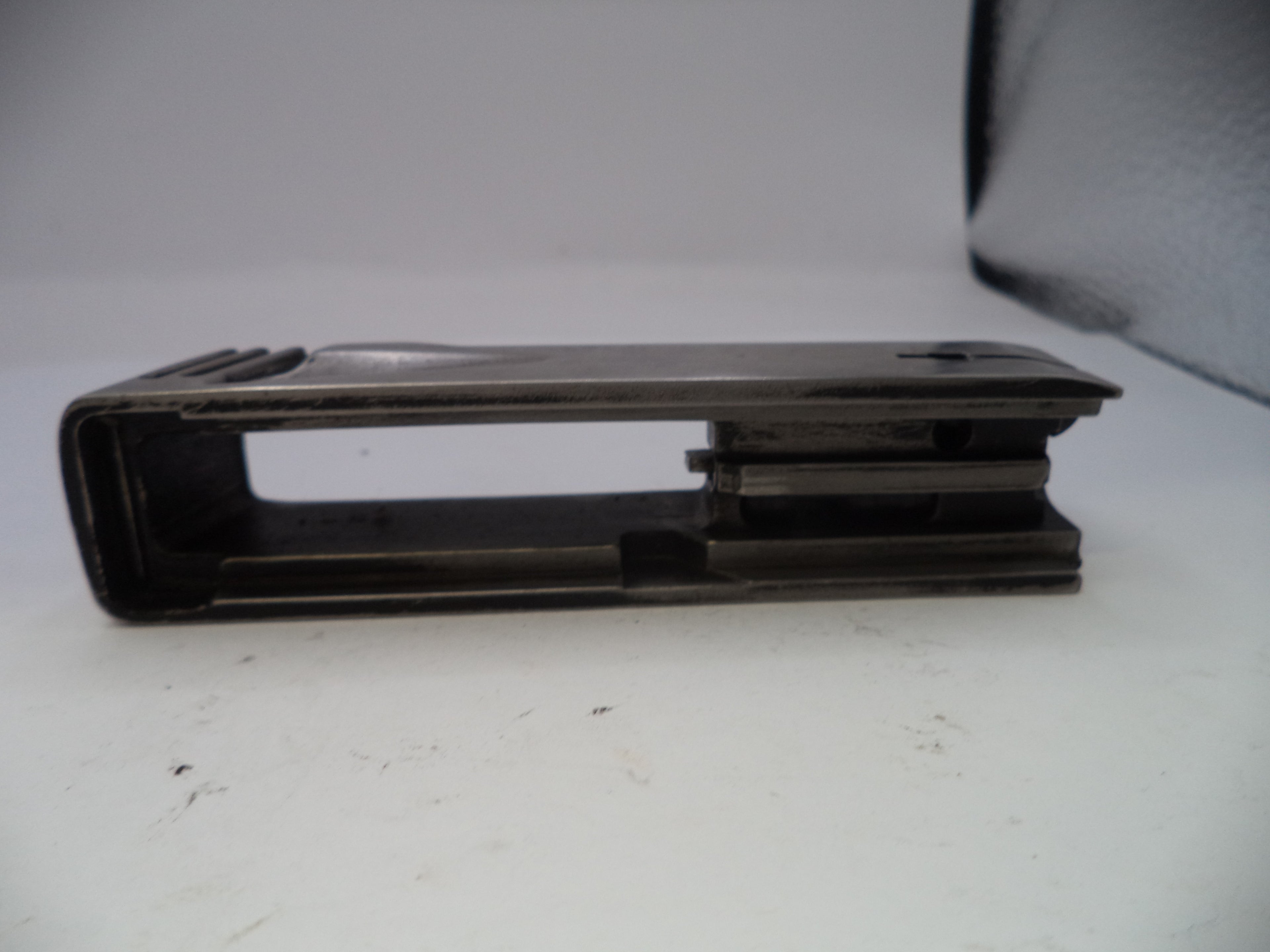 Metal bracket on a white surface with a gray background