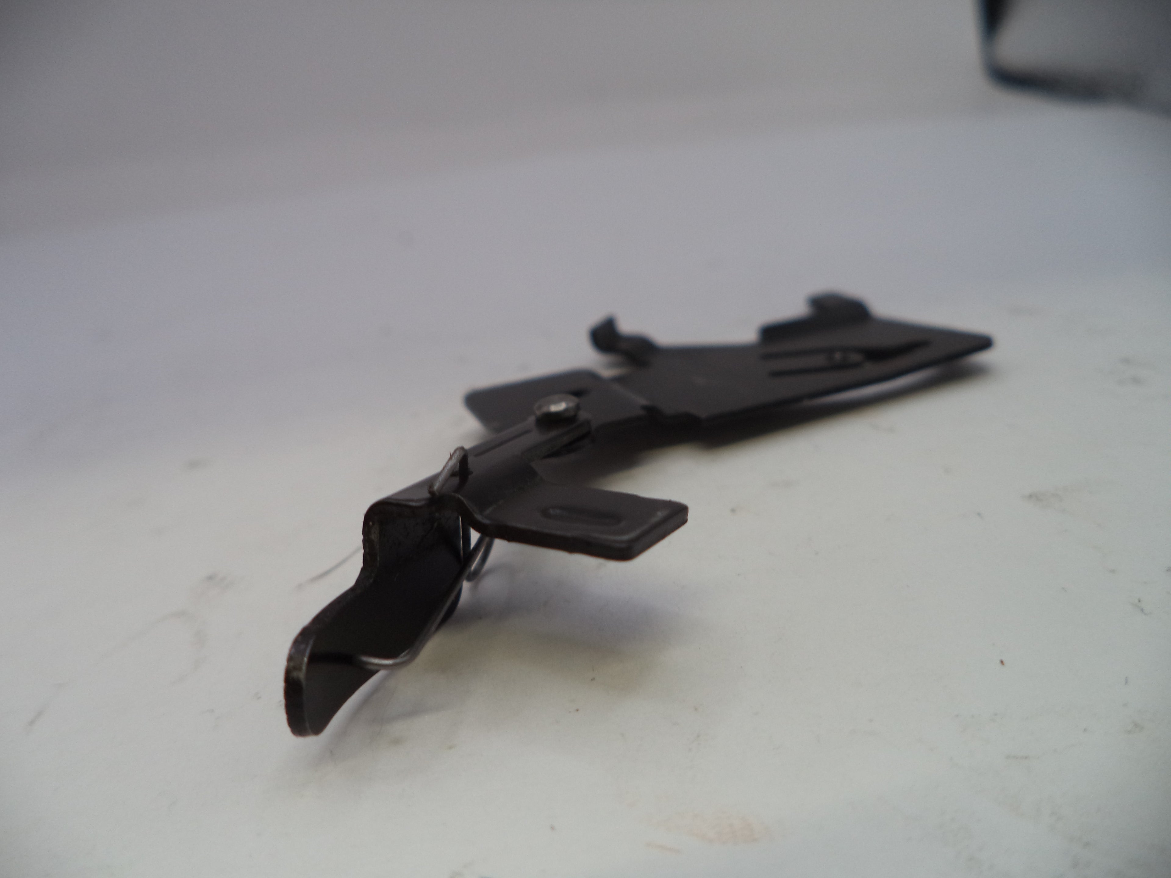 Black metal clip on a white surface