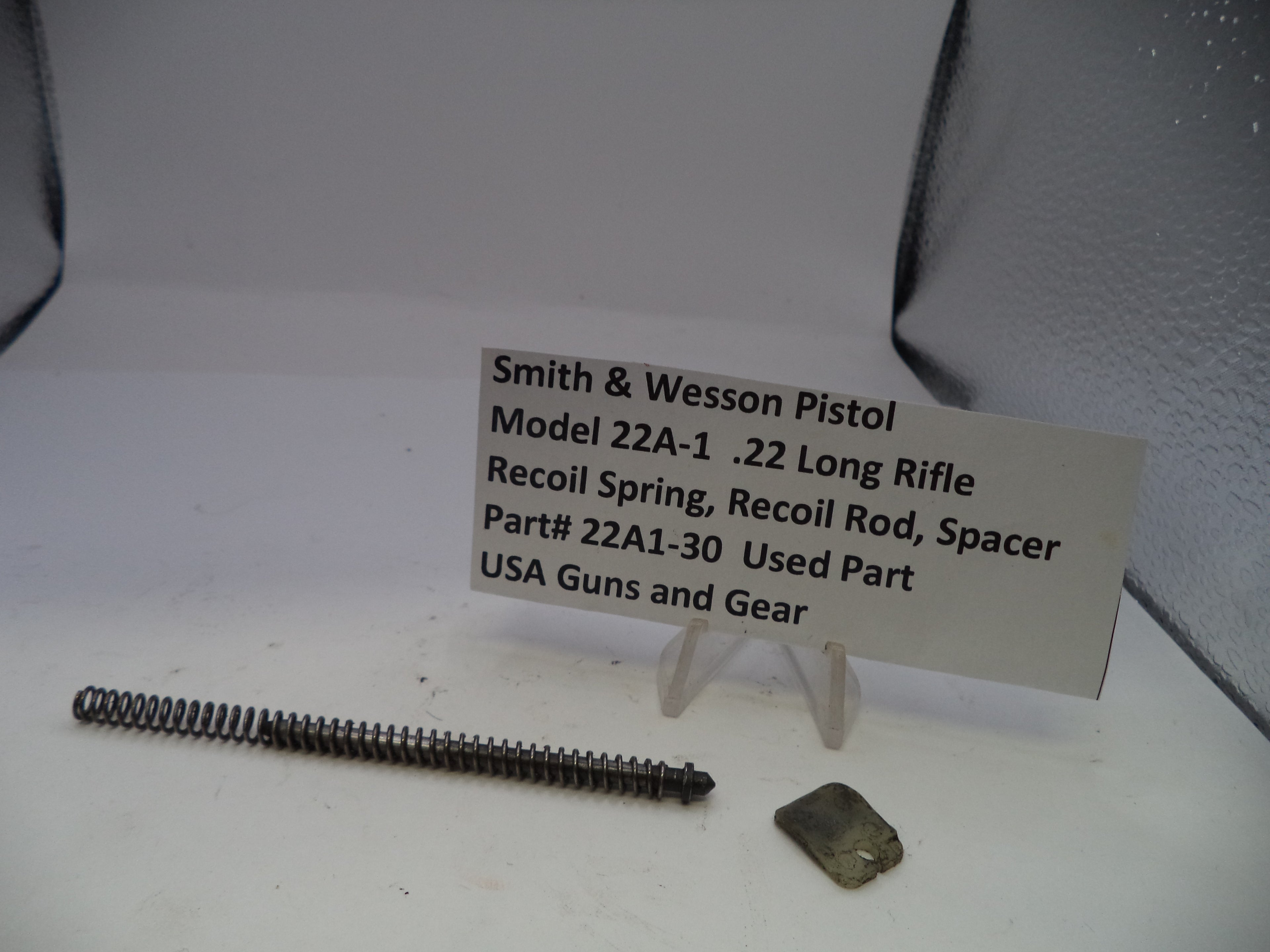 Smith & Wesson pistol part with a label on a white surface