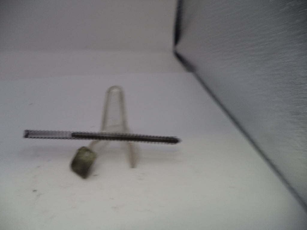 Metallic object on a white surface with a textured background