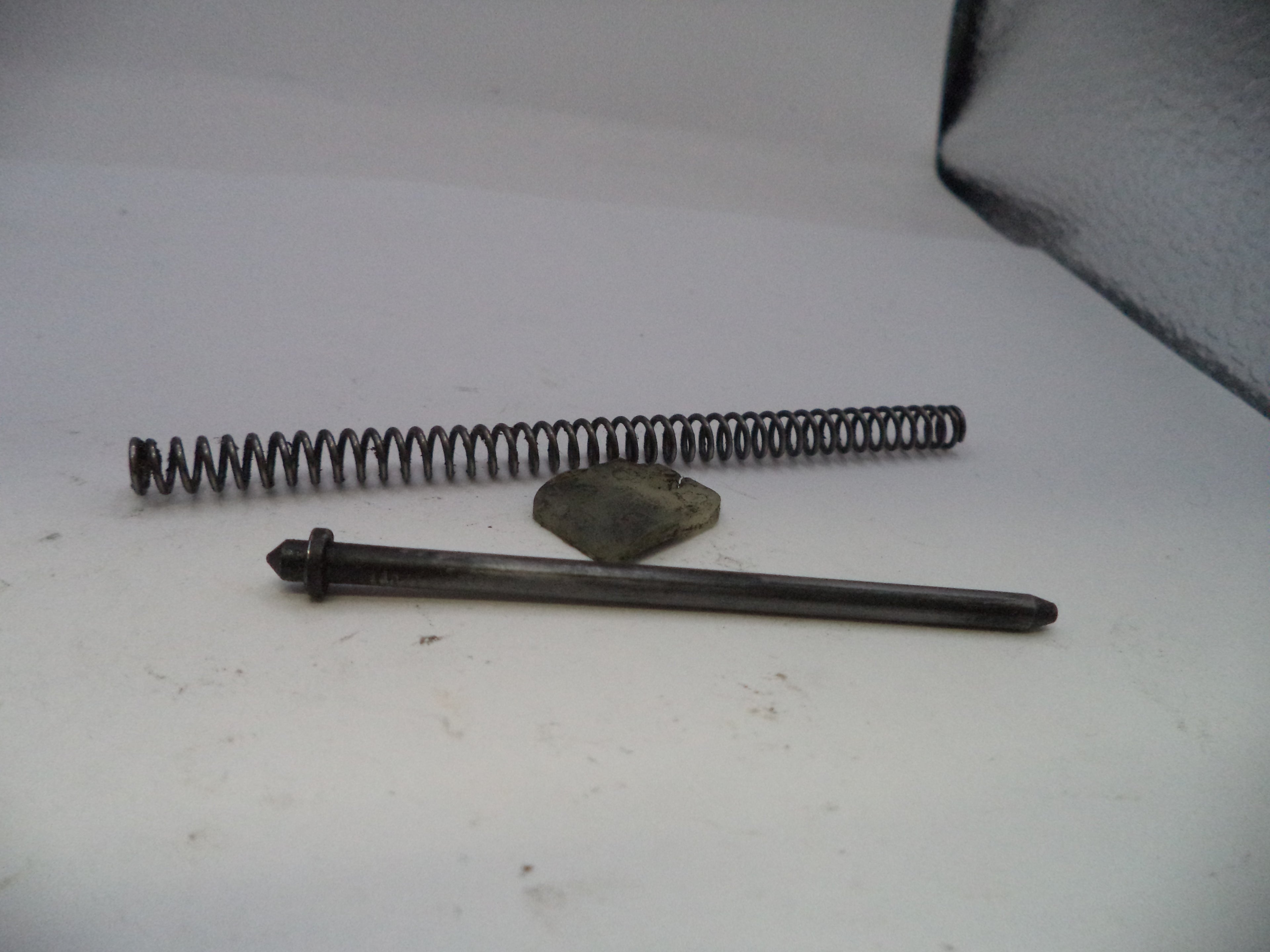 Metal spring and rod on a white surface