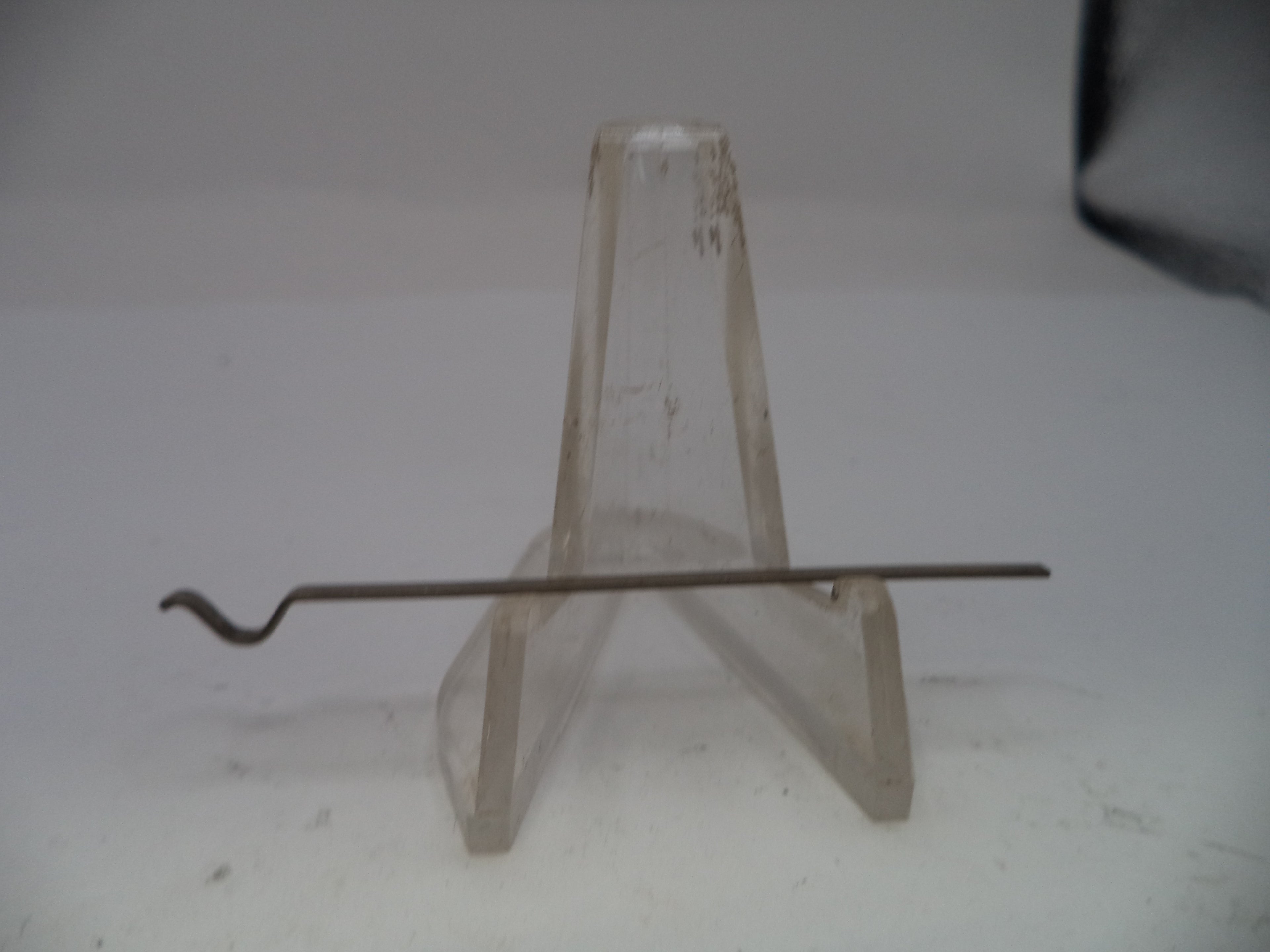 Metal rod on a clear stand against a white background