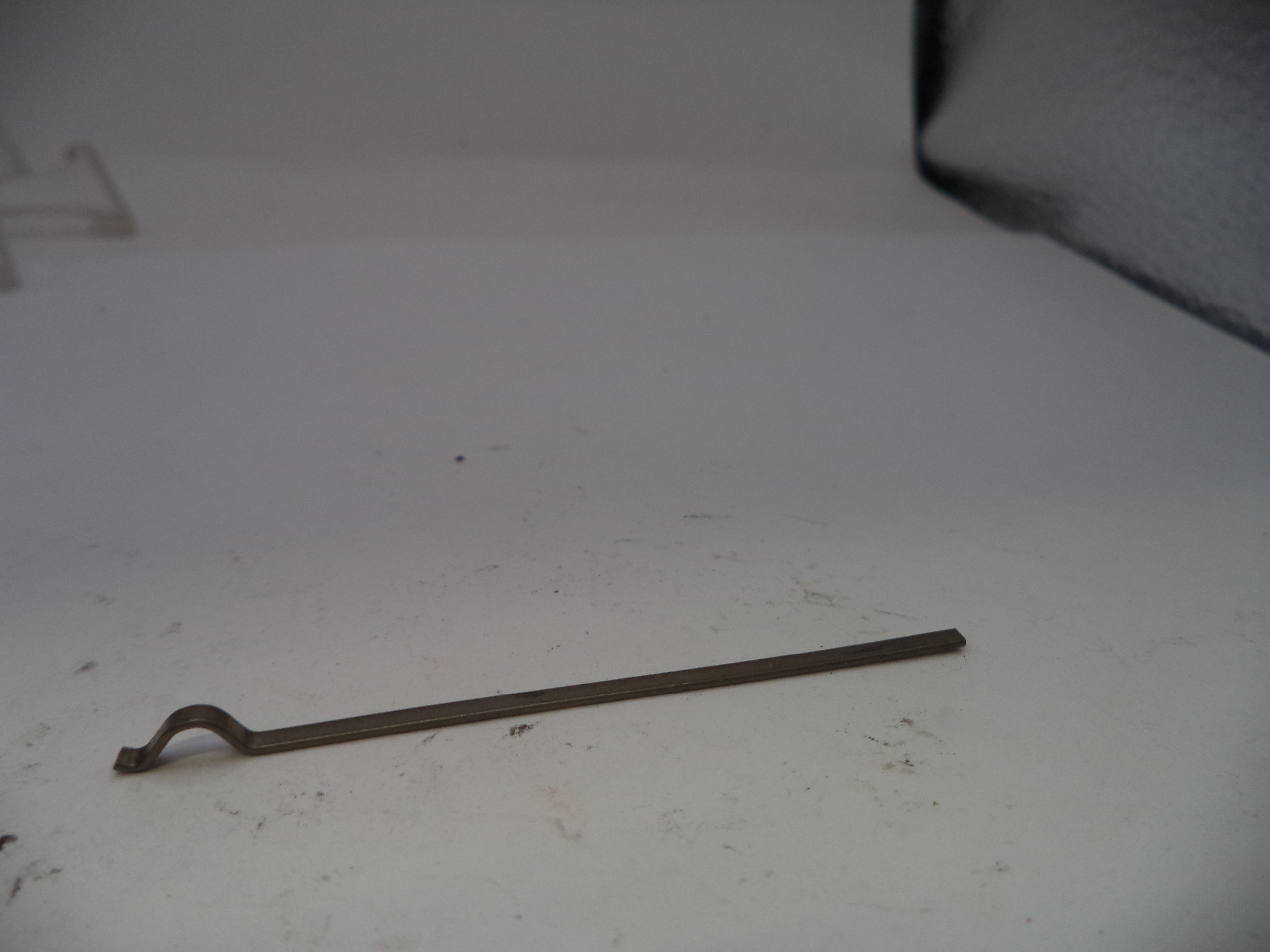 Metal tool on a white surface with a dark background