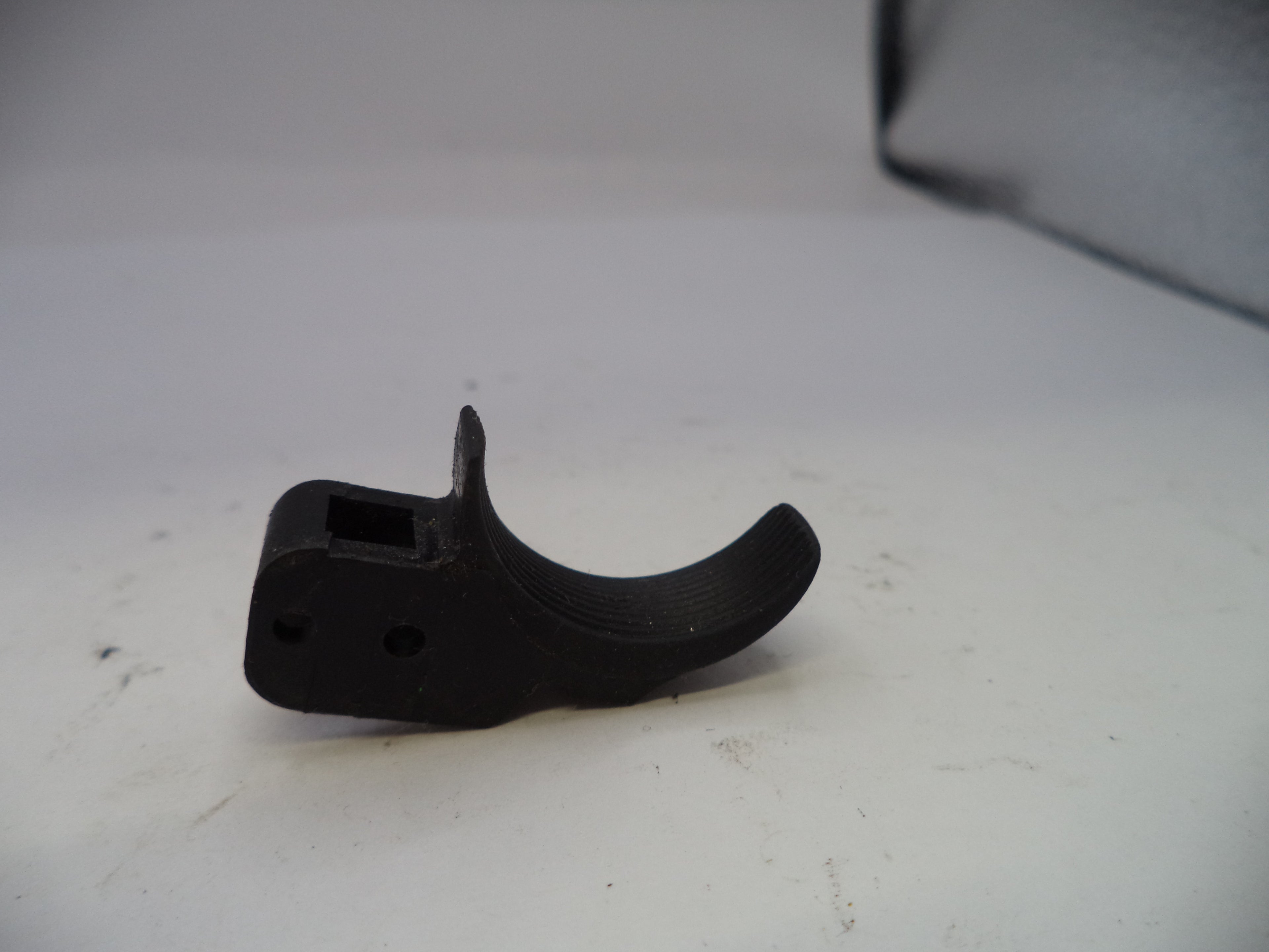 Black plastic component on a white surface