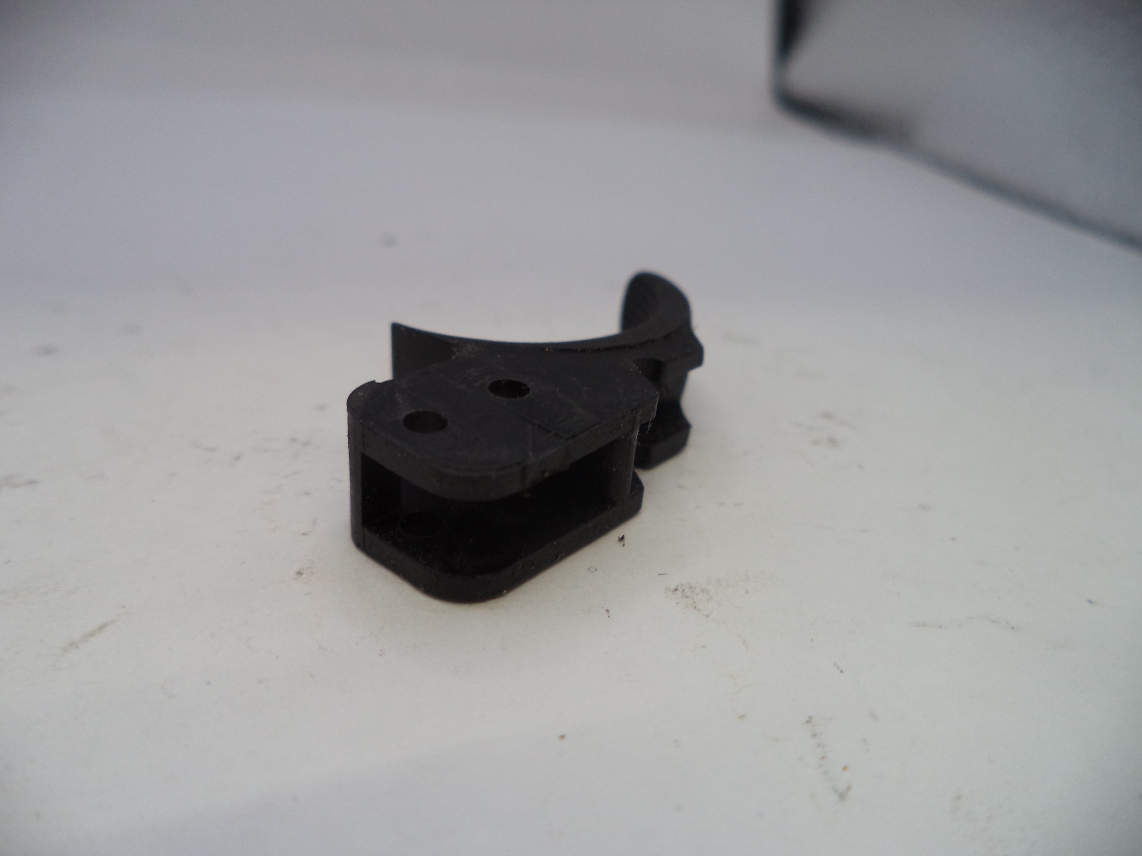 Black plastic component on a white surface