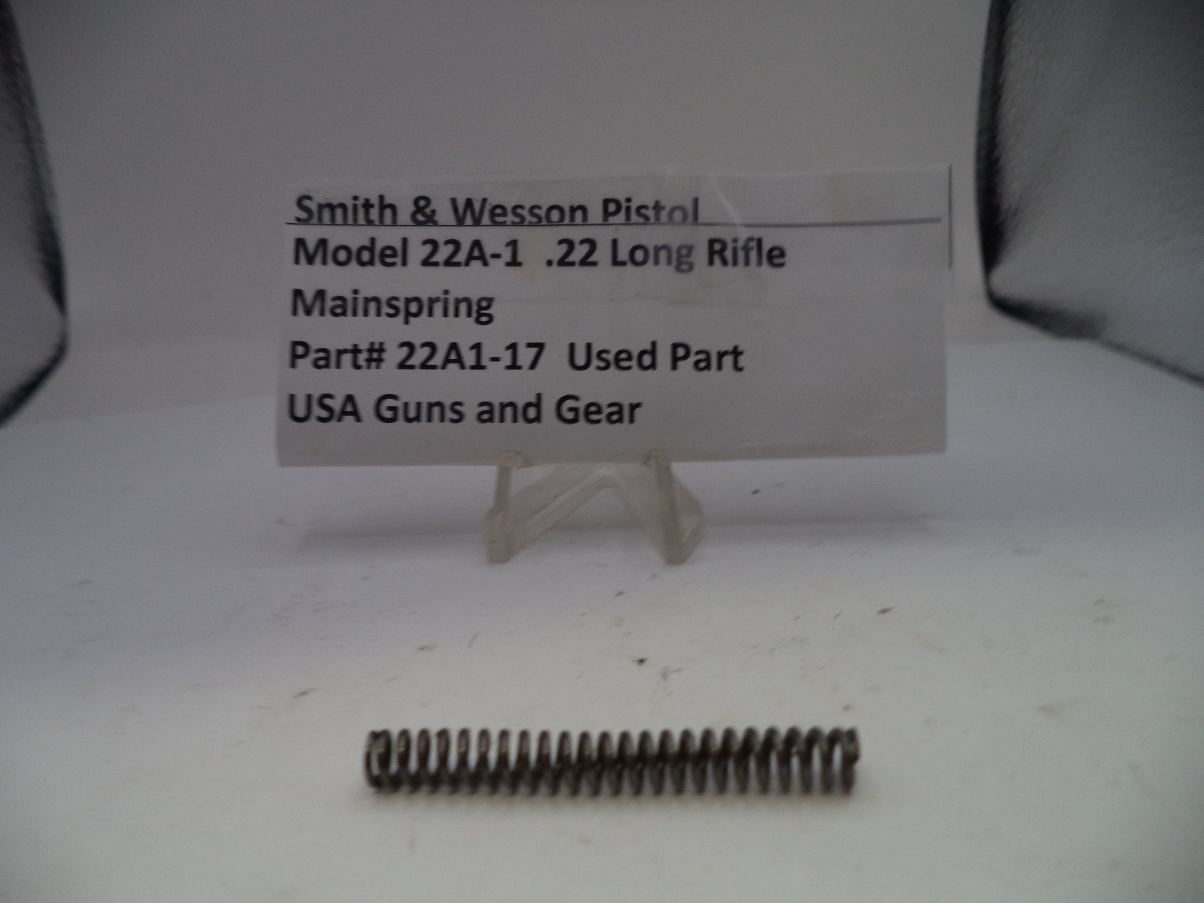 Smith & Wesson pistol mainspring with a label on a white background