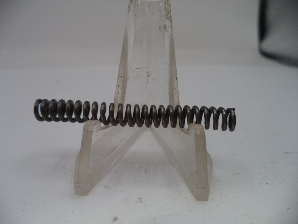 Metal spring on a stand against a plain background