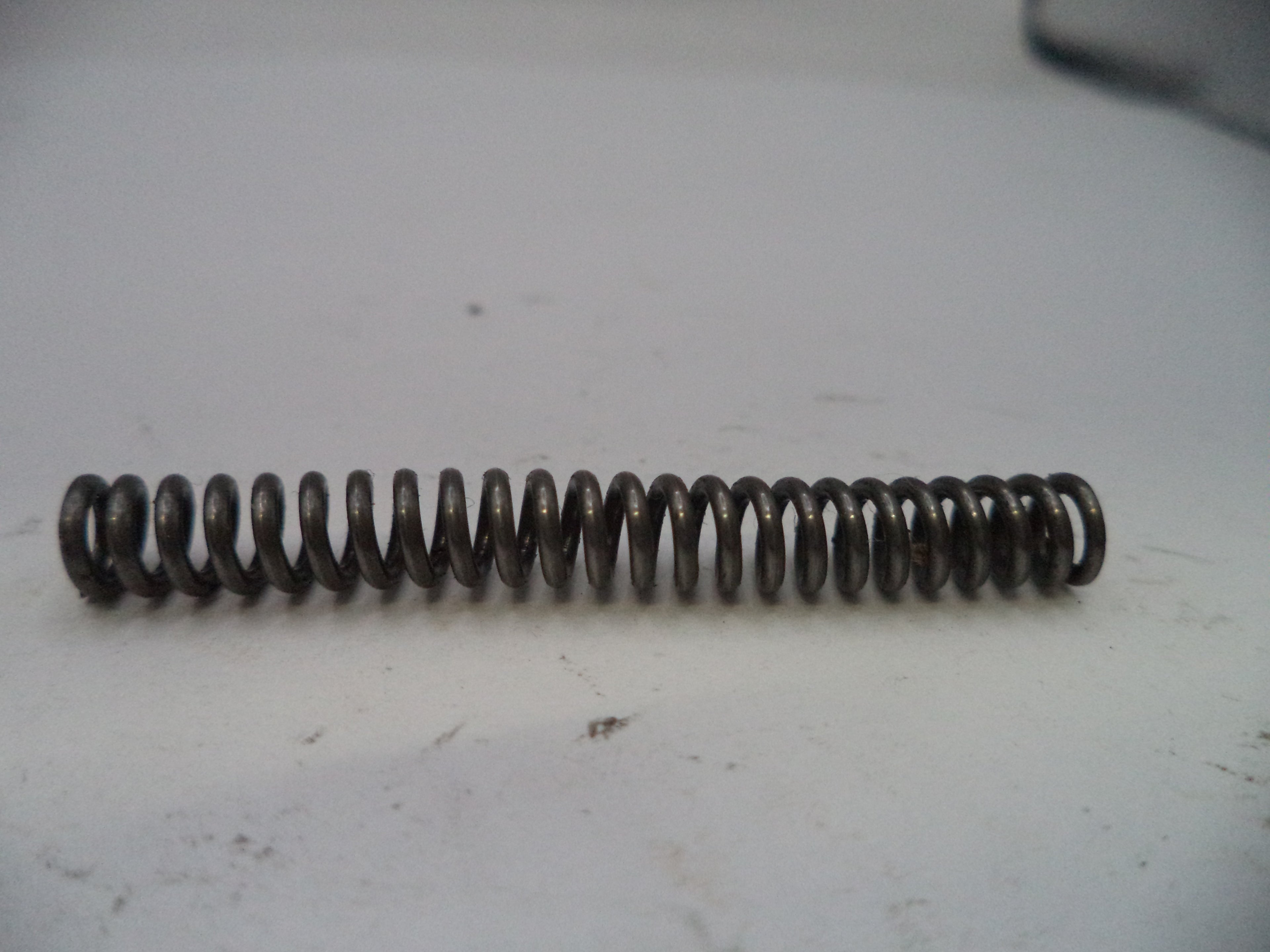Coiled metal spring on a white surface