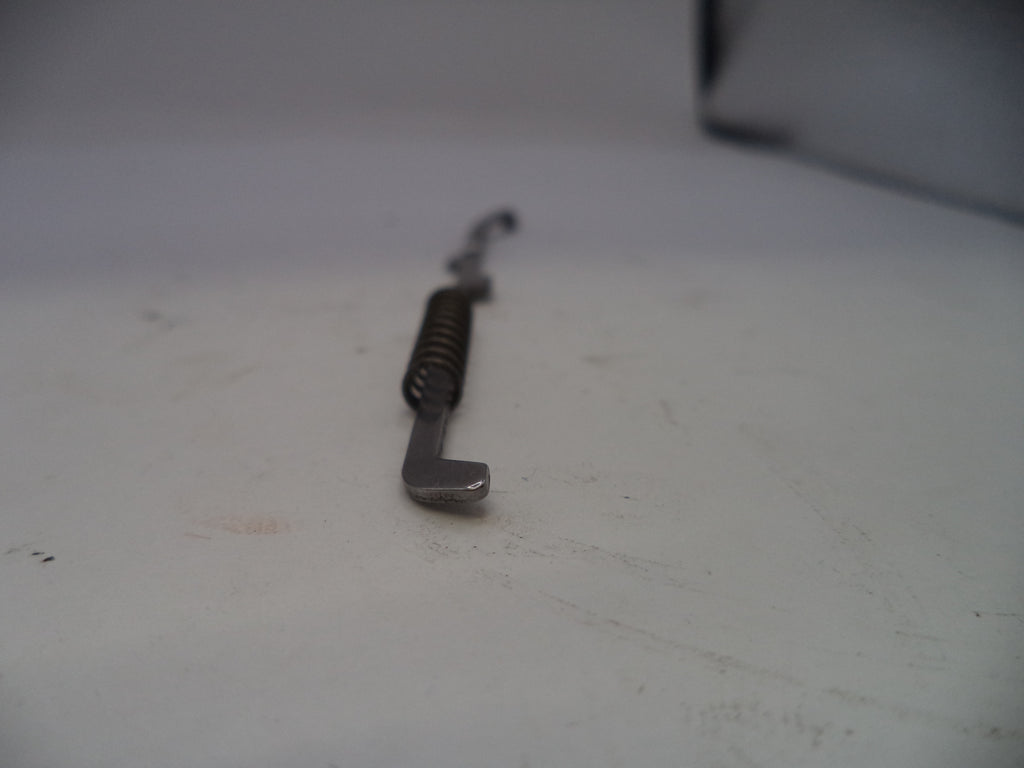 Metallic tool with a spring on a white surface