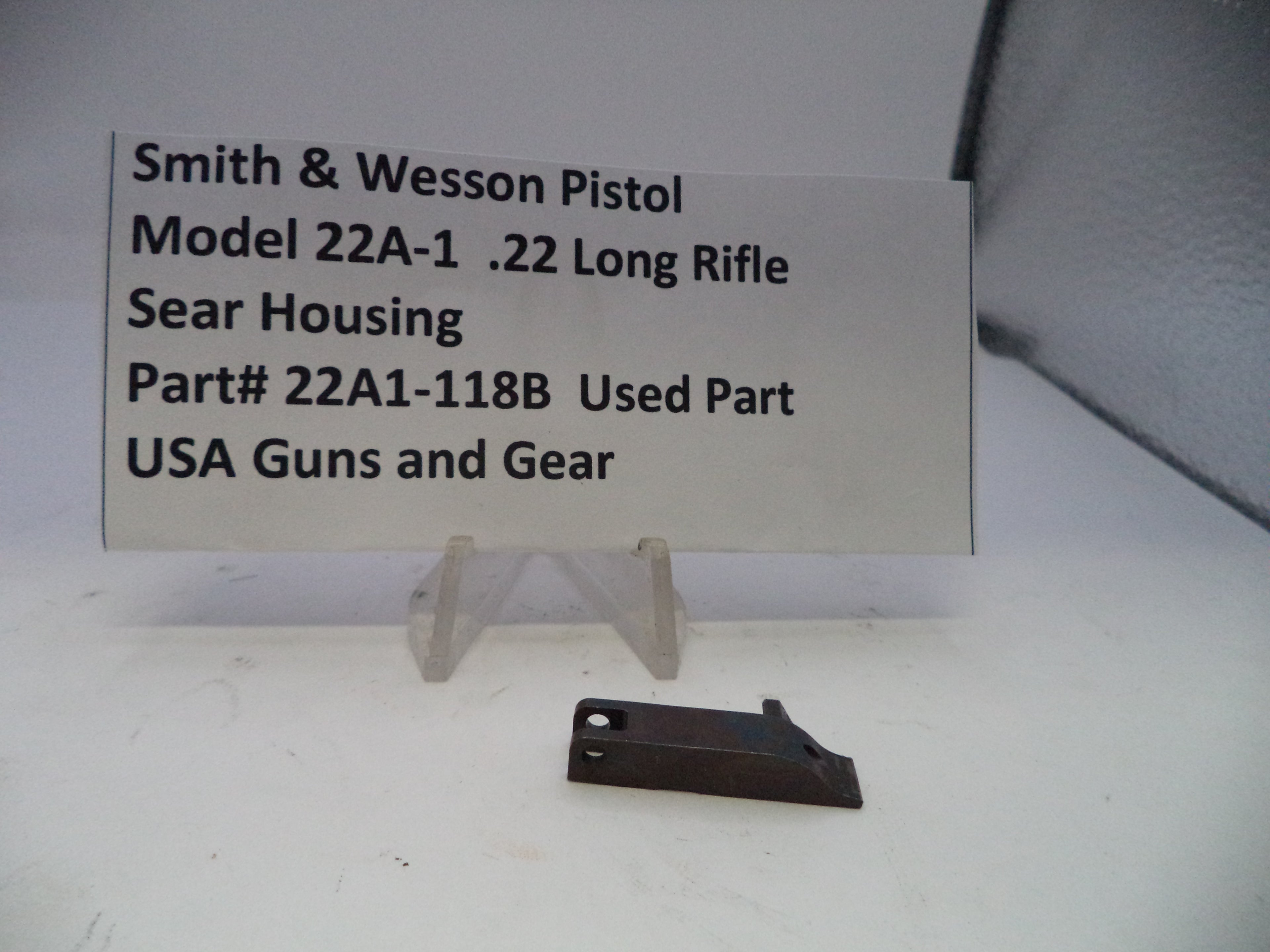 Smith & Wesson pistol part on a white background with a label