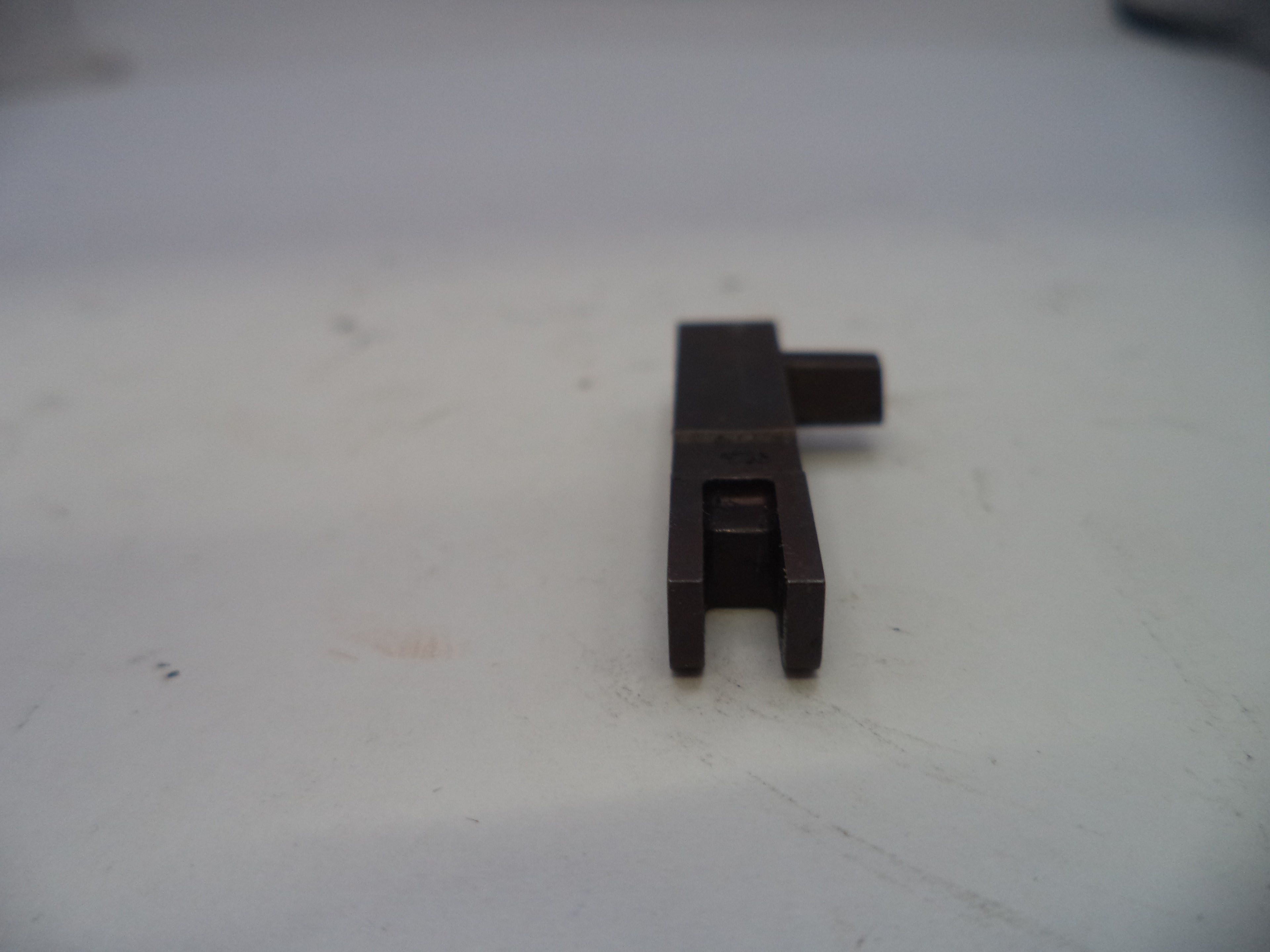 Black metal component on a white surface