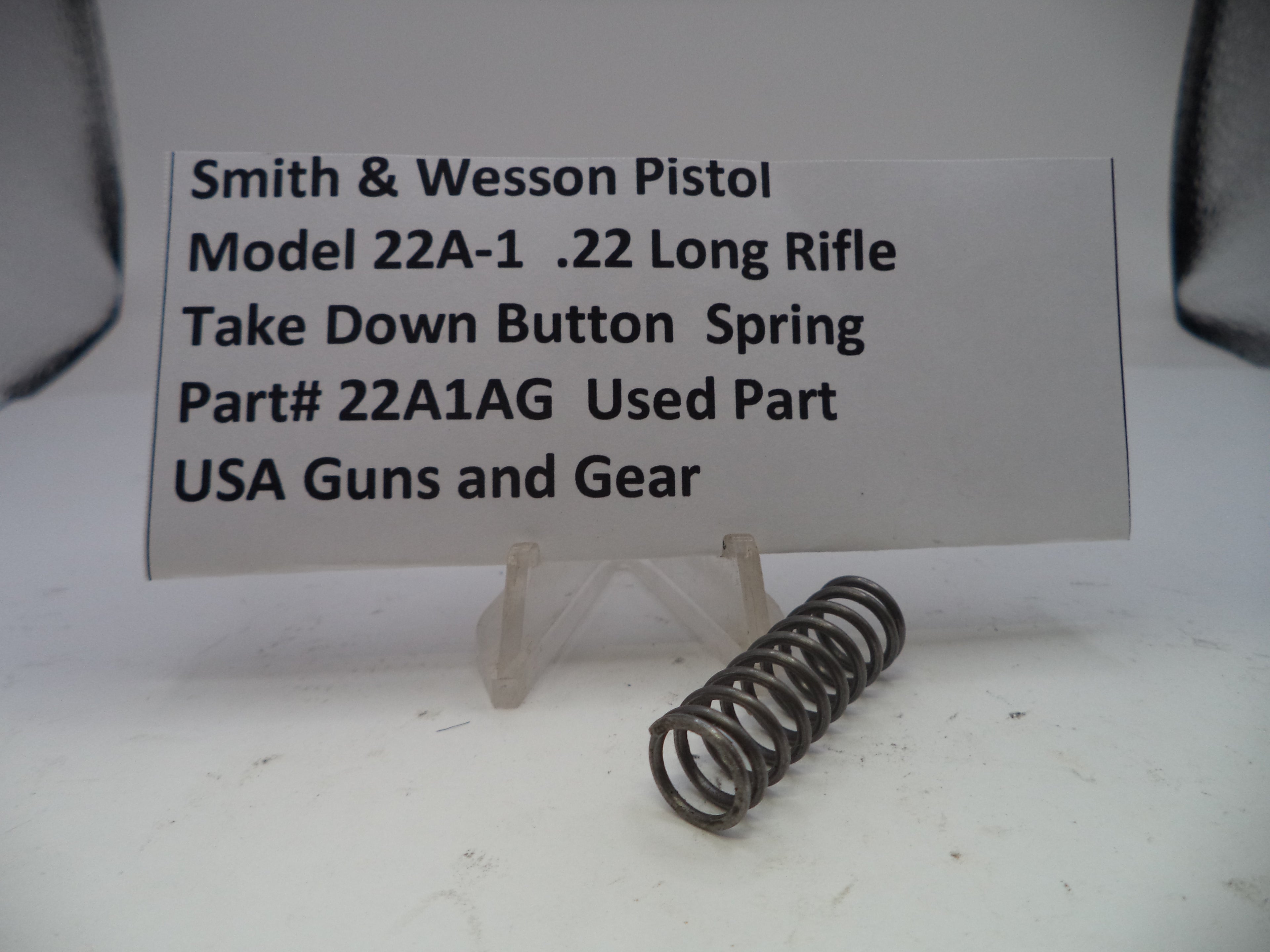 Smith & Wesson pistol part with descriptive label on a white background
