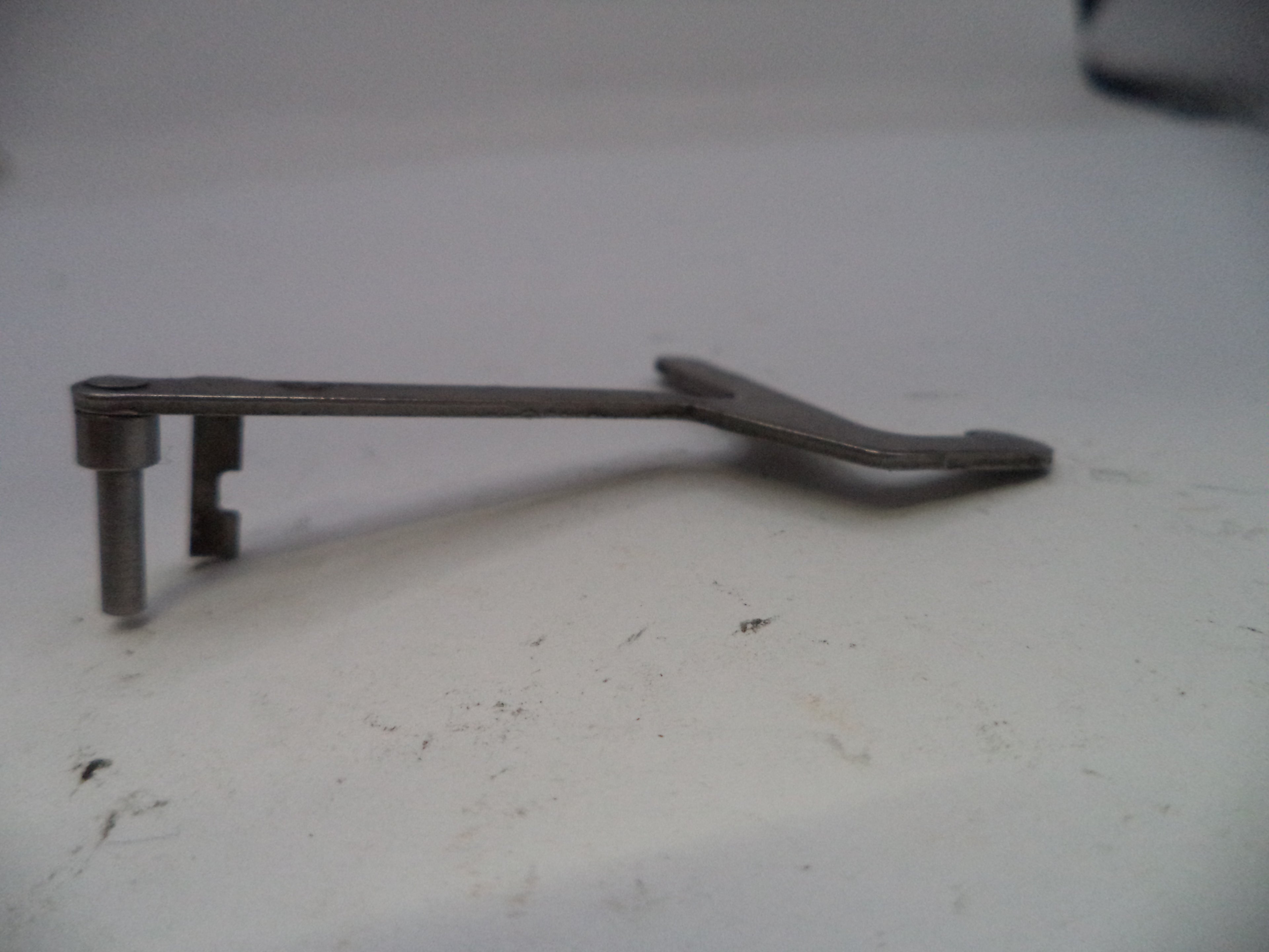 Metal lever or handle on a white surface