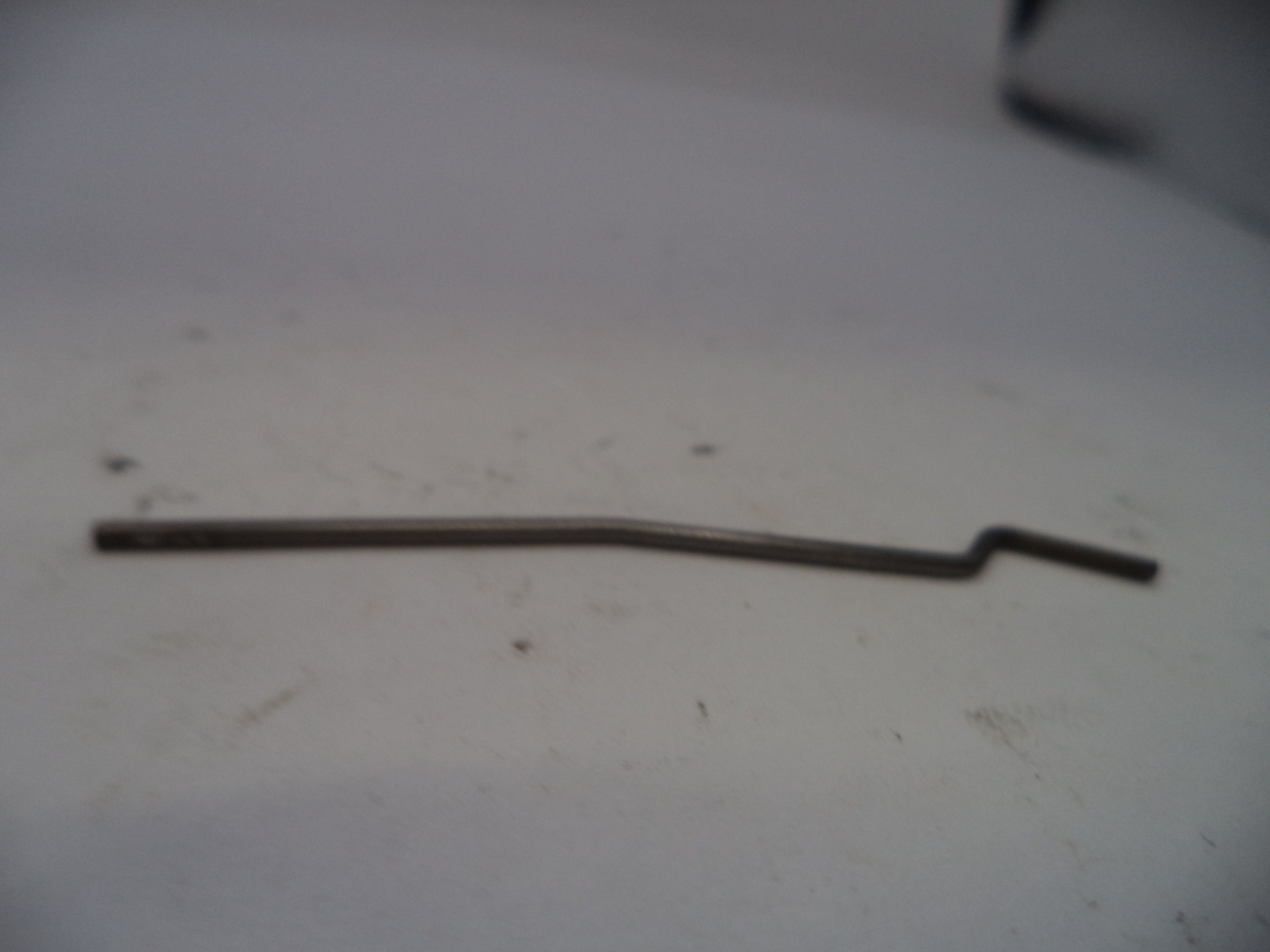 Metal rod on a white surface with a blurred background
