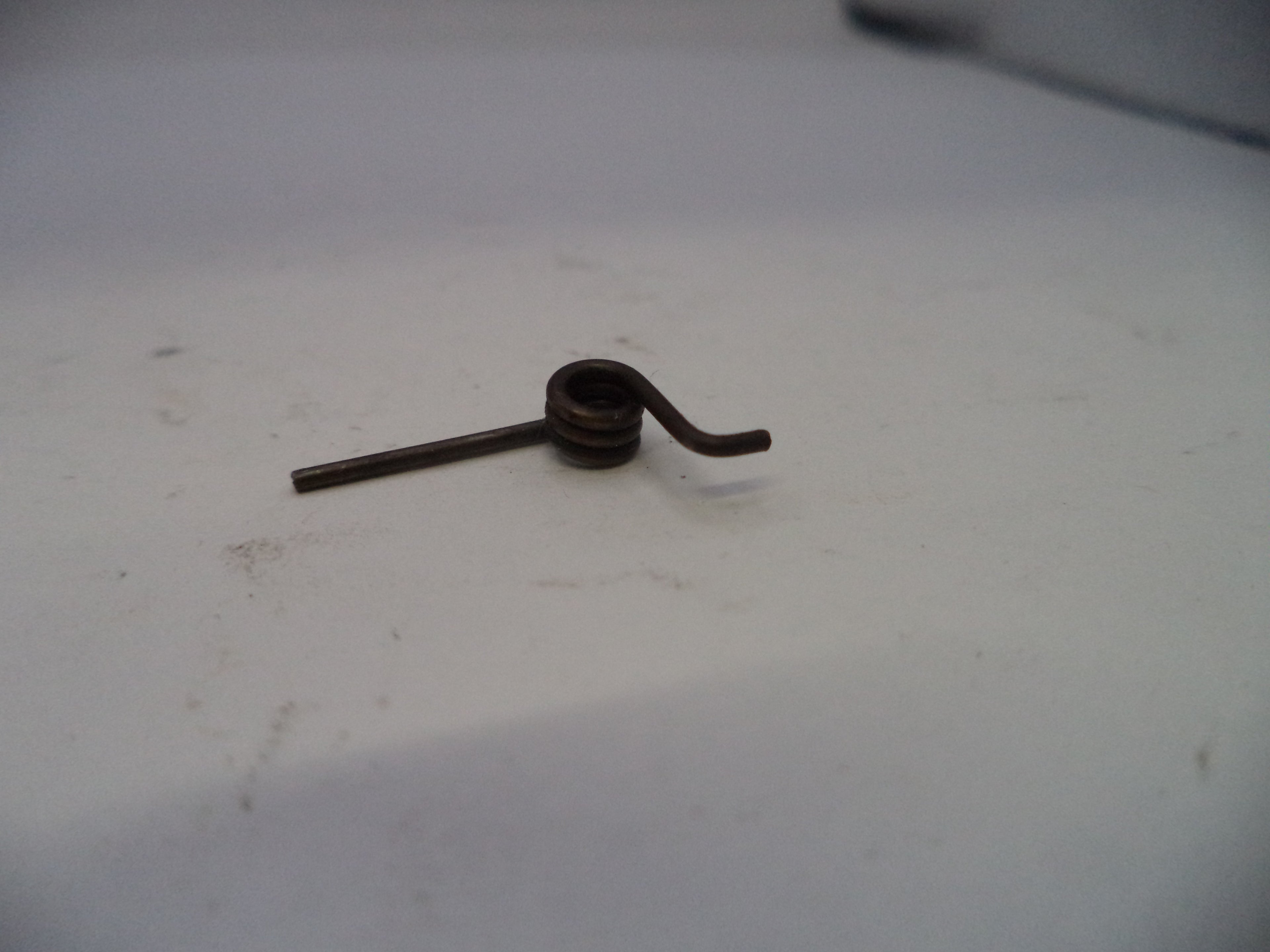 Small metal spring on a white surface
