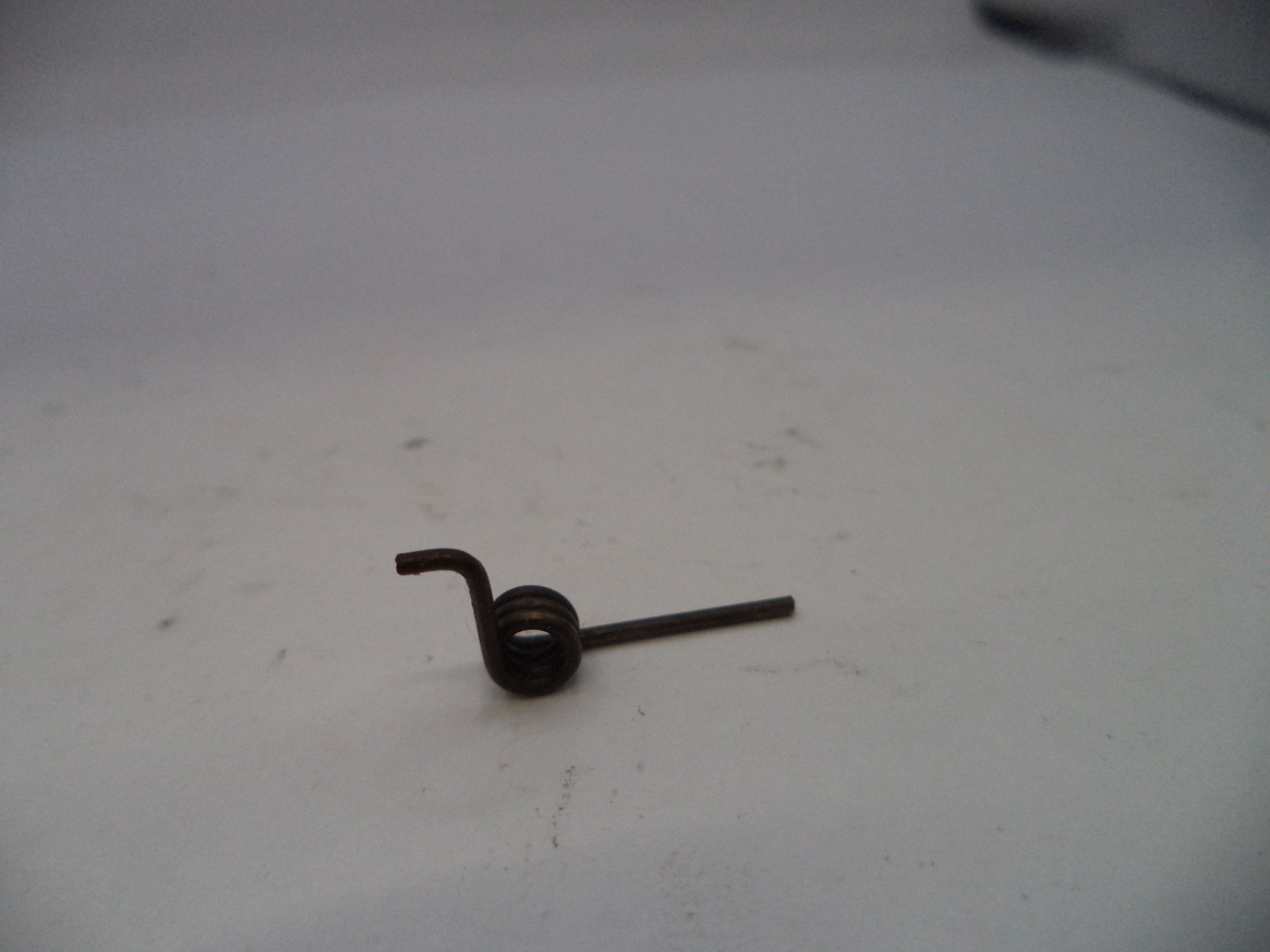 Small metal spring on a white surface