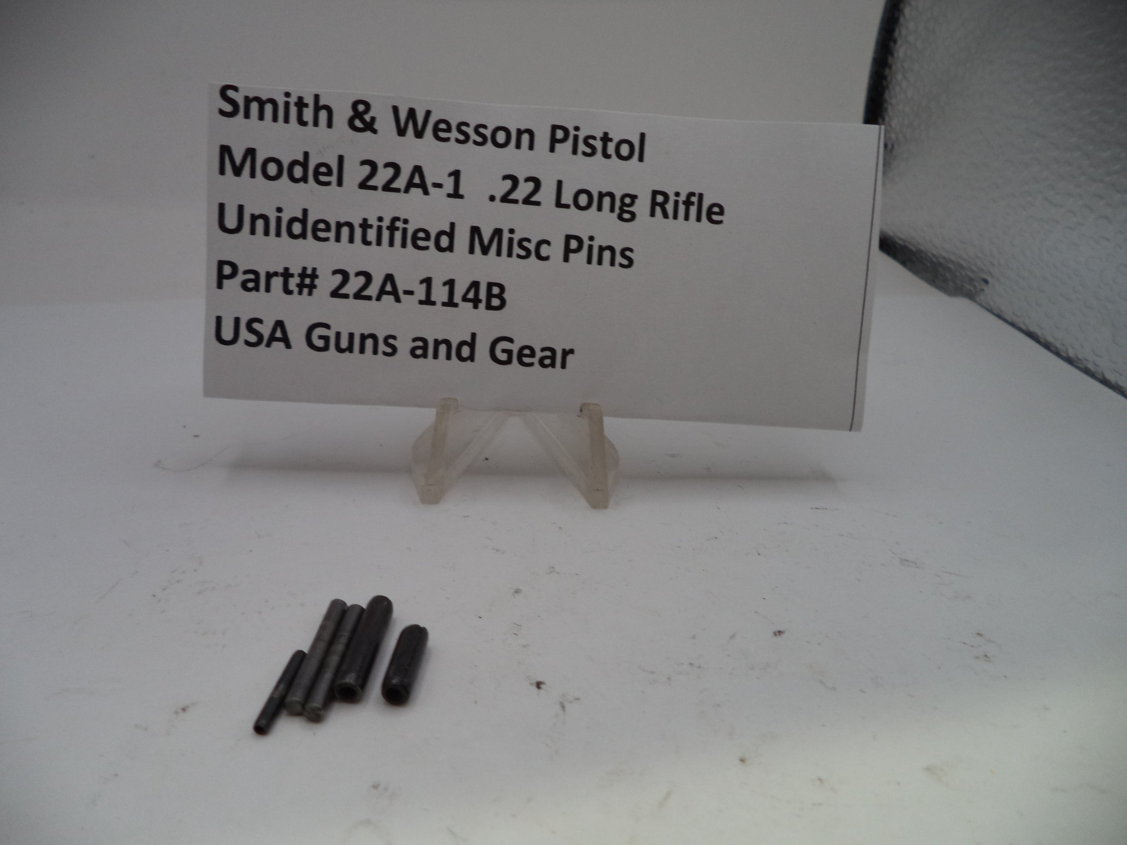 Smith & Wesson pistol parts on a white background with a label.