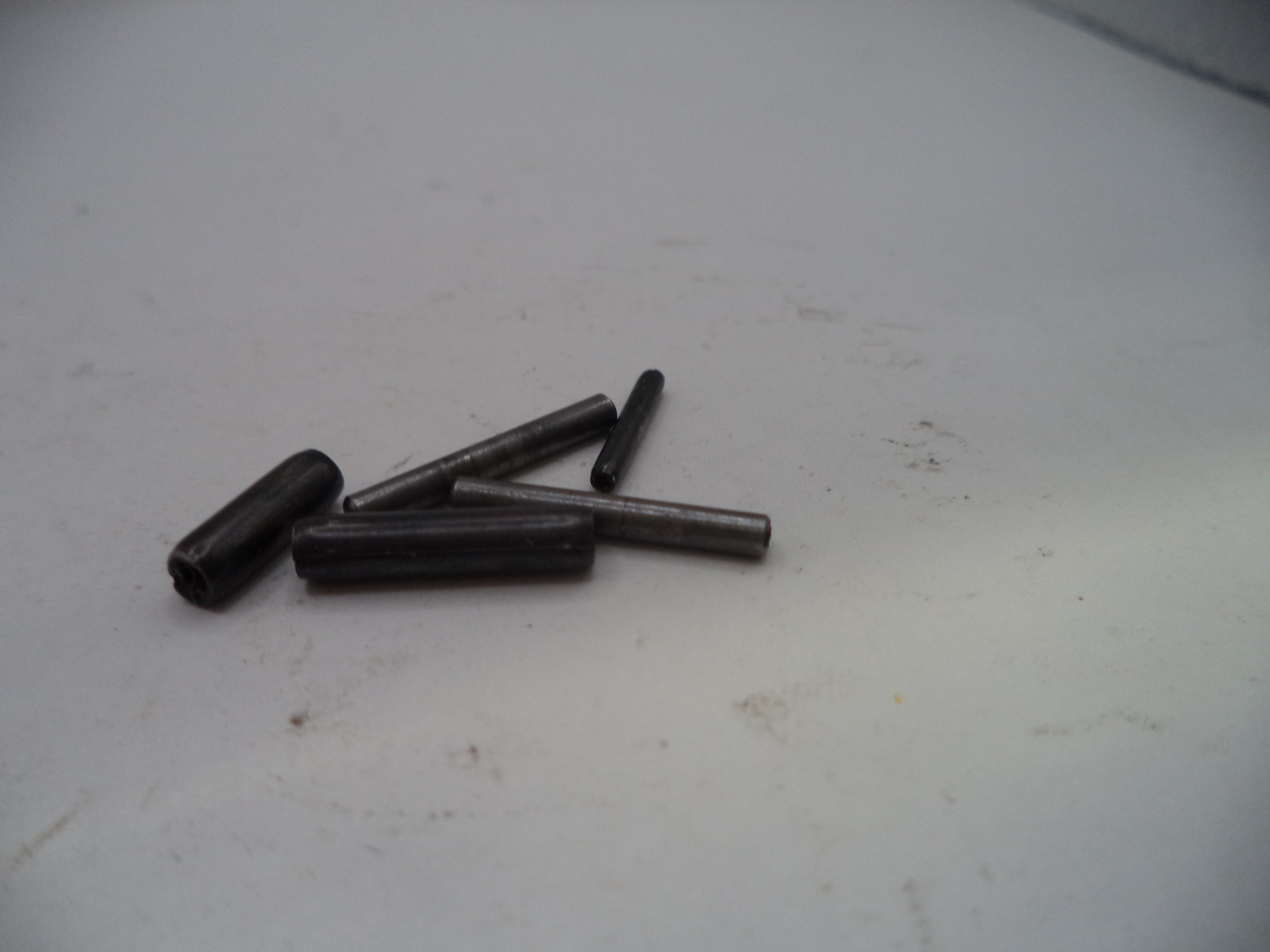 Four black cylindrical objects on a white surface