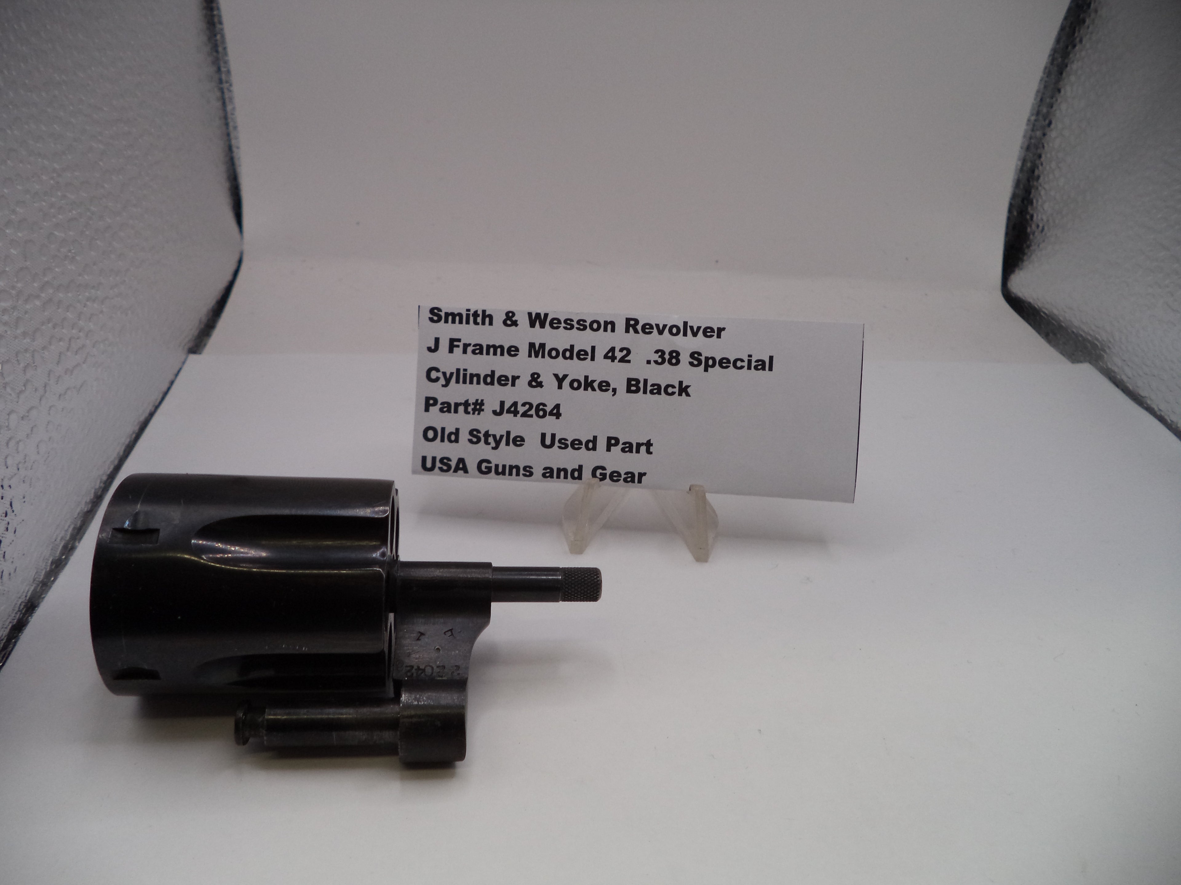 Smith & Wesson revolver cylinder and yoke on a white background with a label.